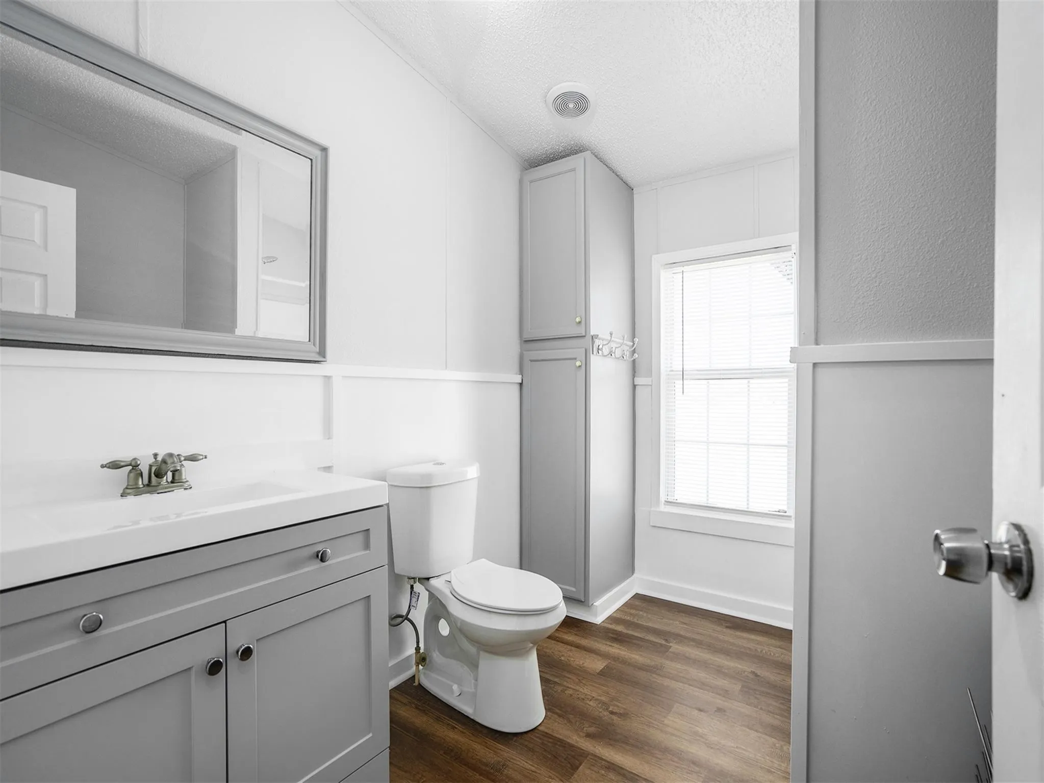 Bathroom featuring a textured ceiling, dark wood finished floors, and vanity