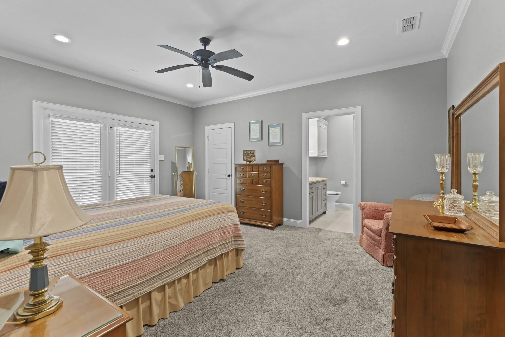 Recessed lighting, crown molding, double French doors, ceiling fan, and carpet flooring