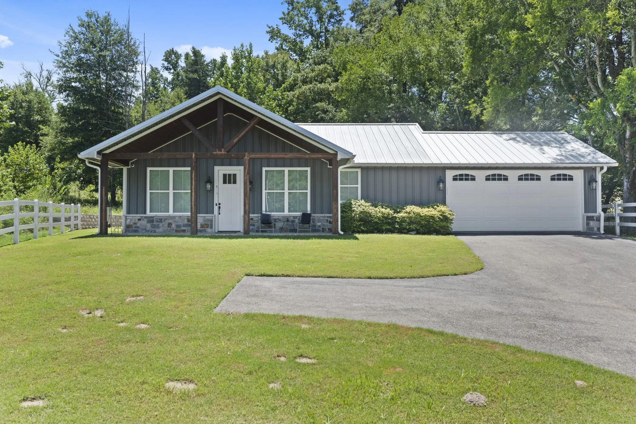 Modern farmhouse exterior with board and batten siding, stone facade, and a metal roof