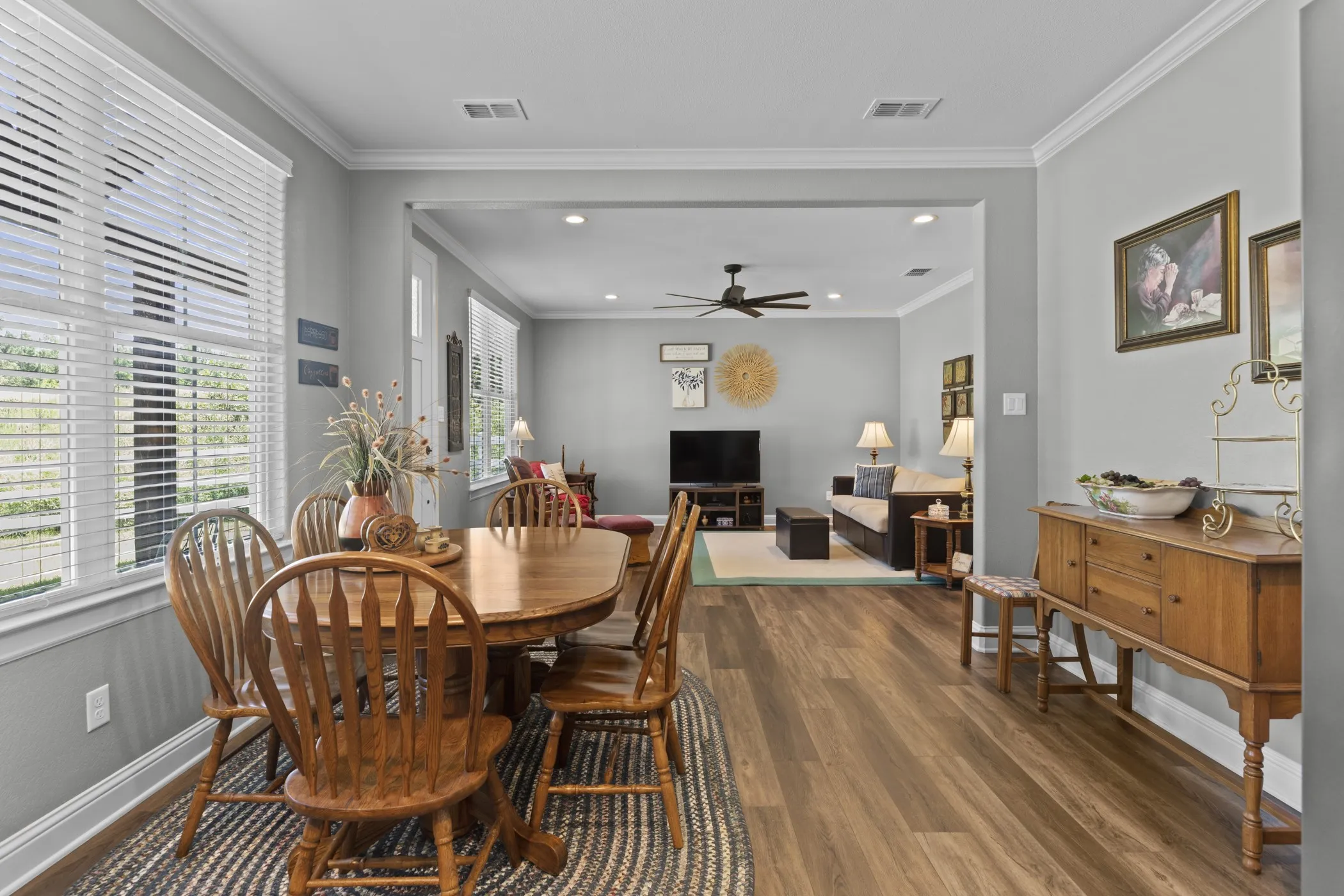Open-concept design with crown molding, recessed lighting, wood-finish flooring, and multiple windows