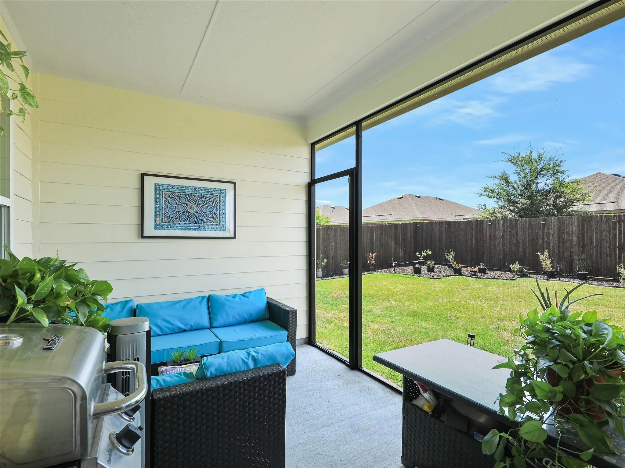 From the main living area, step outside to the screened-in covered porch overlooking the backyard.