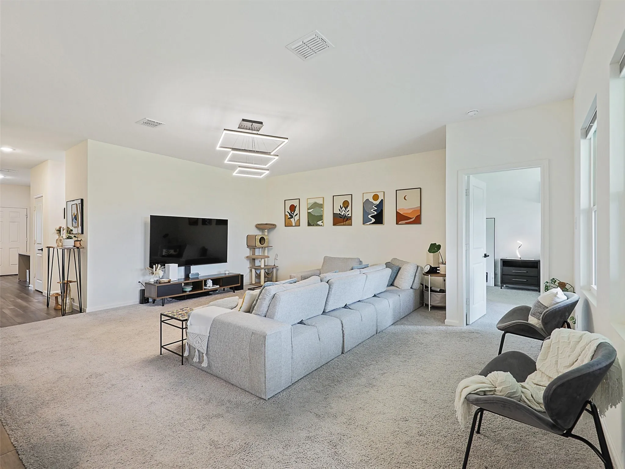The living room has large windows with views toward the backyard.