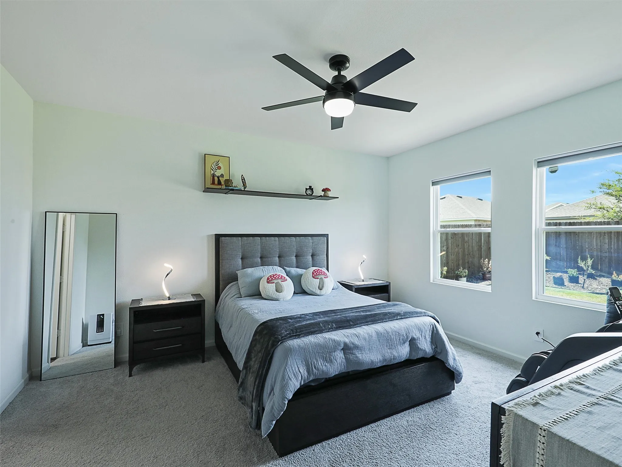Moving into the primary bedroom, multiple windows bring in natural light.