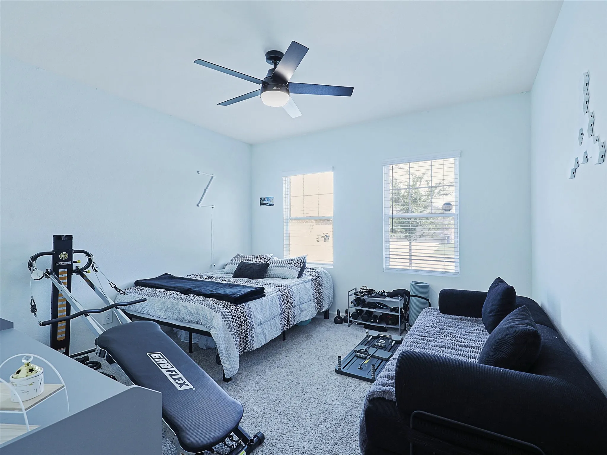 Moving to the secondary bedroom, multiple windows bring in natural light.