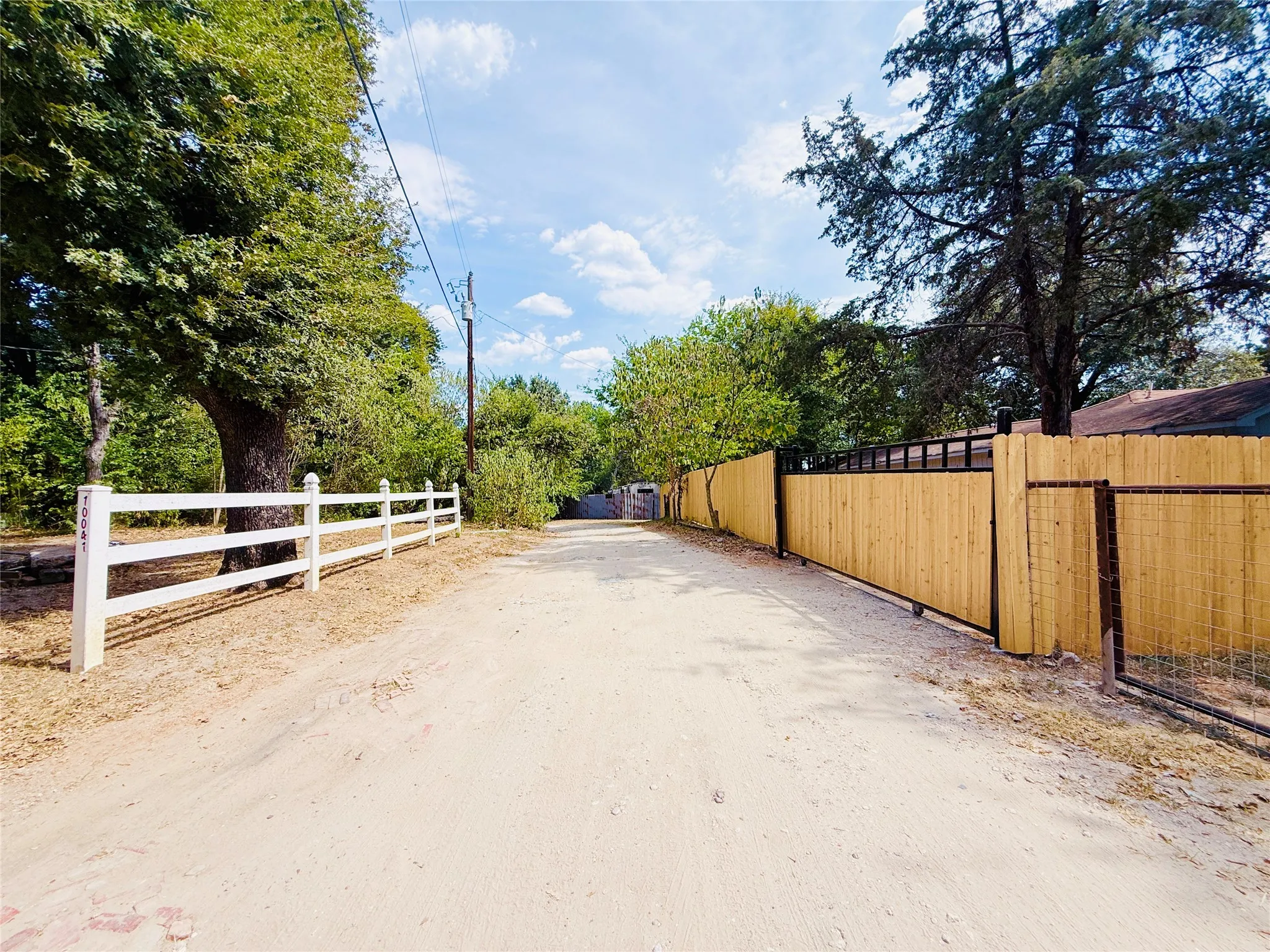 Metal-framed sliding gate with wood fencing