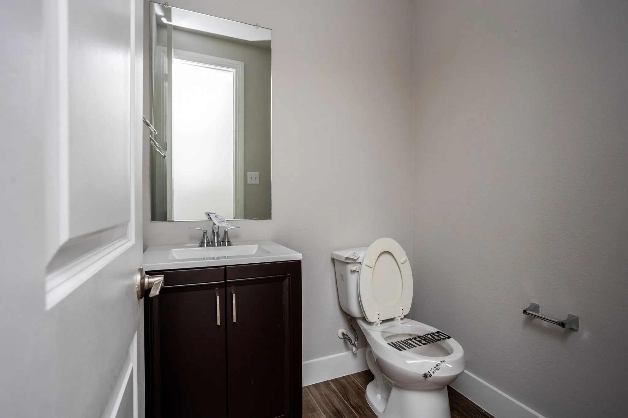 Dark wood-finish vanity with a white countertop and rectangular undermount sink