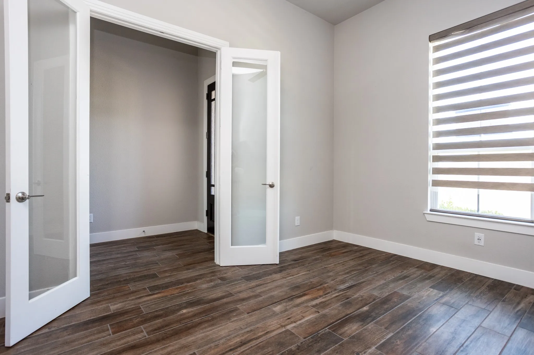 Wood-look tile flooring, neutral wall tones, and white trim