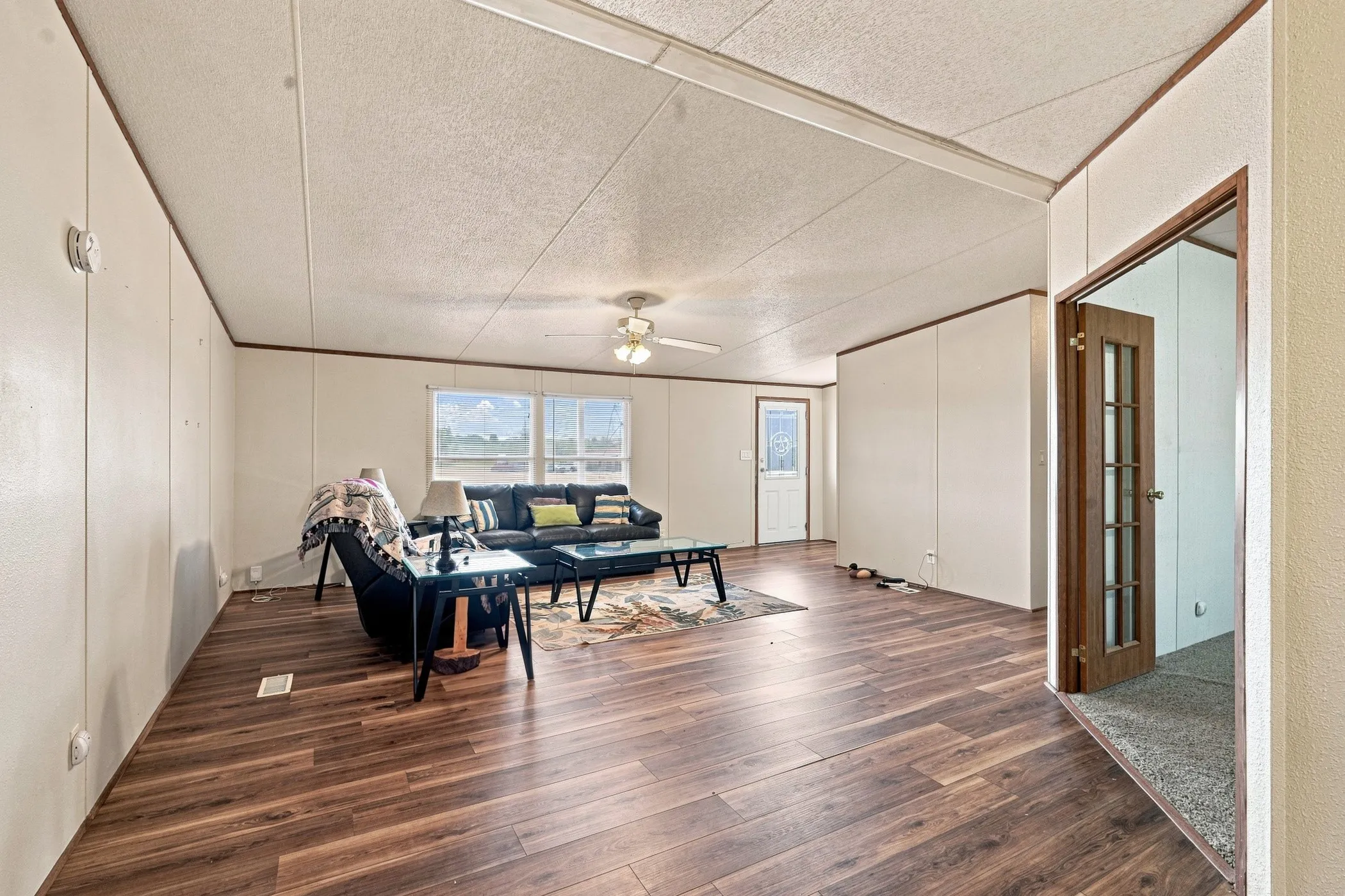 Spacious living area overlooking the front entry way, in the right of the photo is the dedicated office area or second living area with French doors that offers privacy