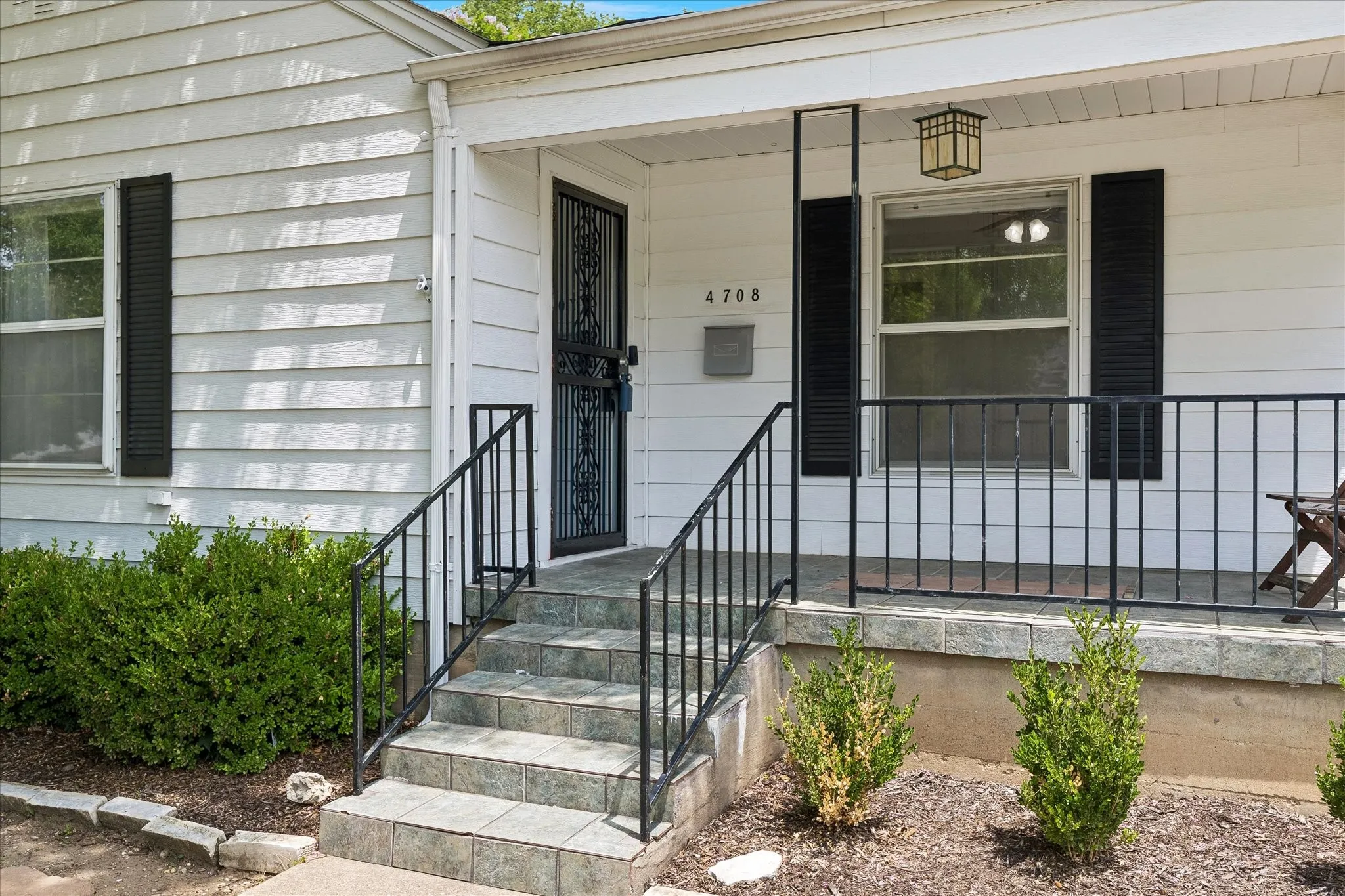 White siding exterior with black window shutters
