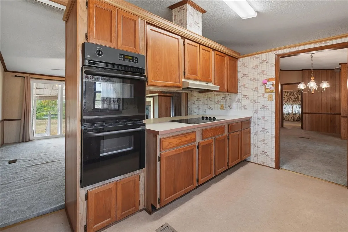 Kitchen featuring wood cabinetry, a built-in double oven, and a cooktop