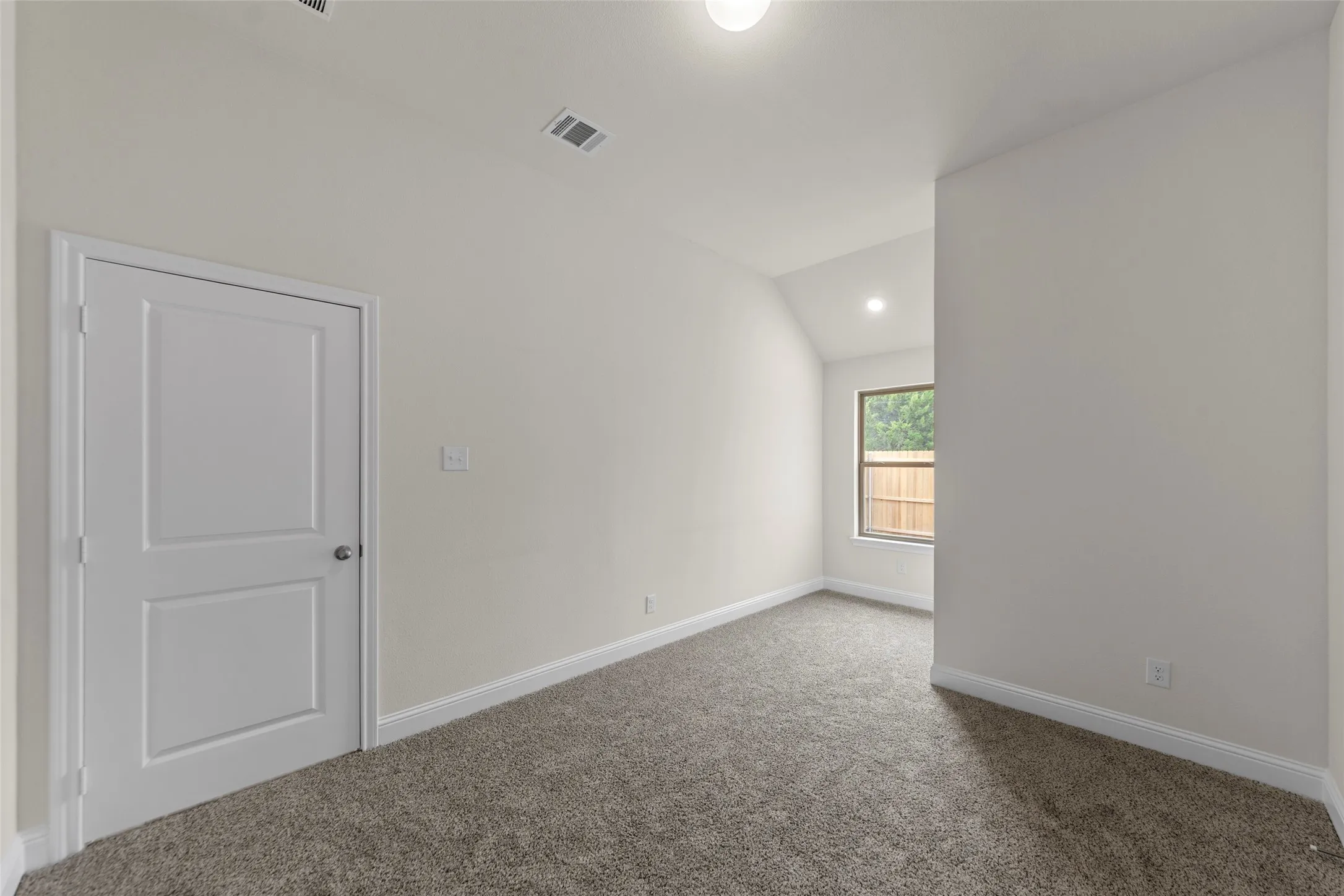 Neutral wall finishes with a single window, recessed lighting, and carpet flooring
