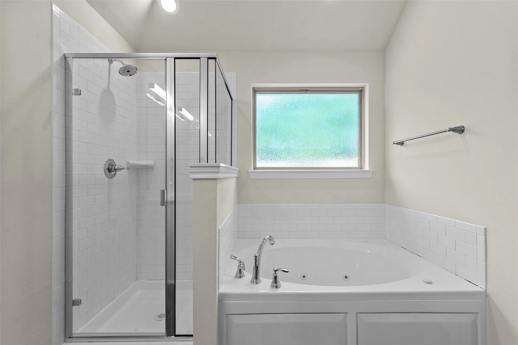 Enclosed shower with subway tile surround, clear glass door, and chrome fixtures