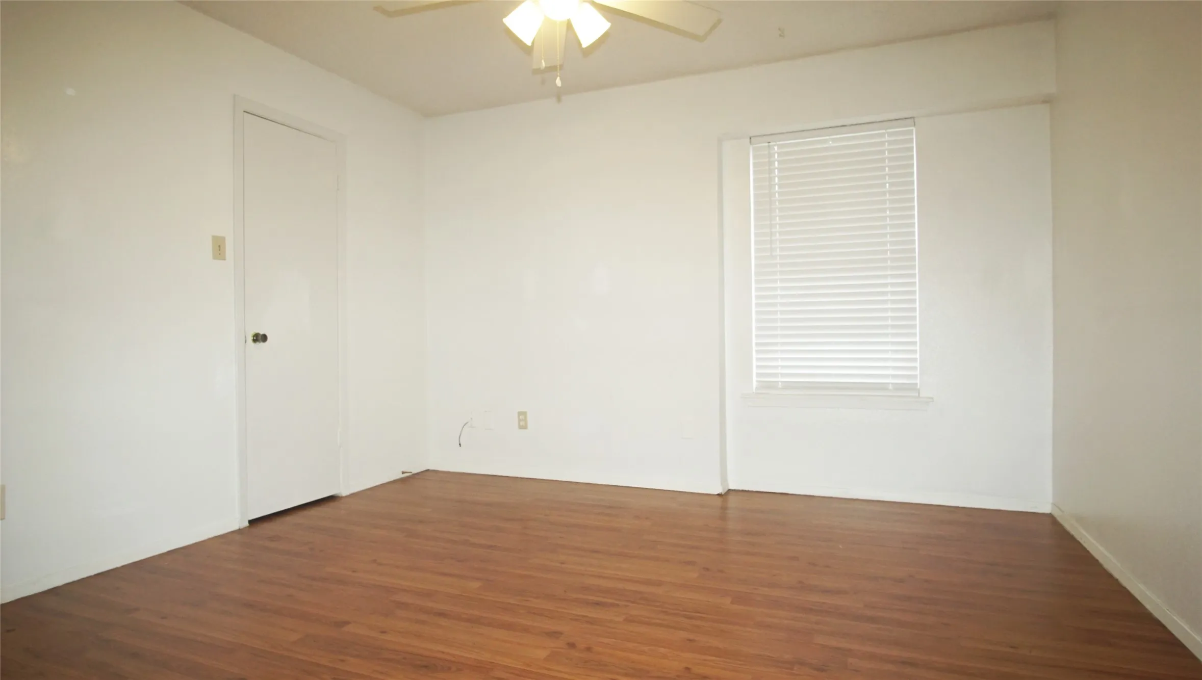 Spare room with a ceiling fan and wood finished floors