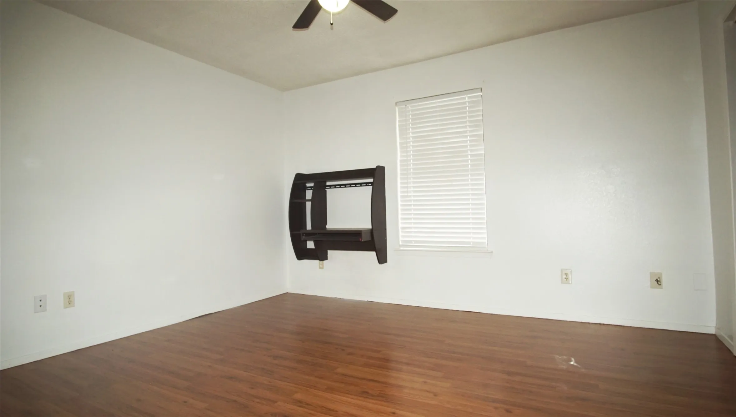 Spare room with a ceiling fan and dark wood finished floors