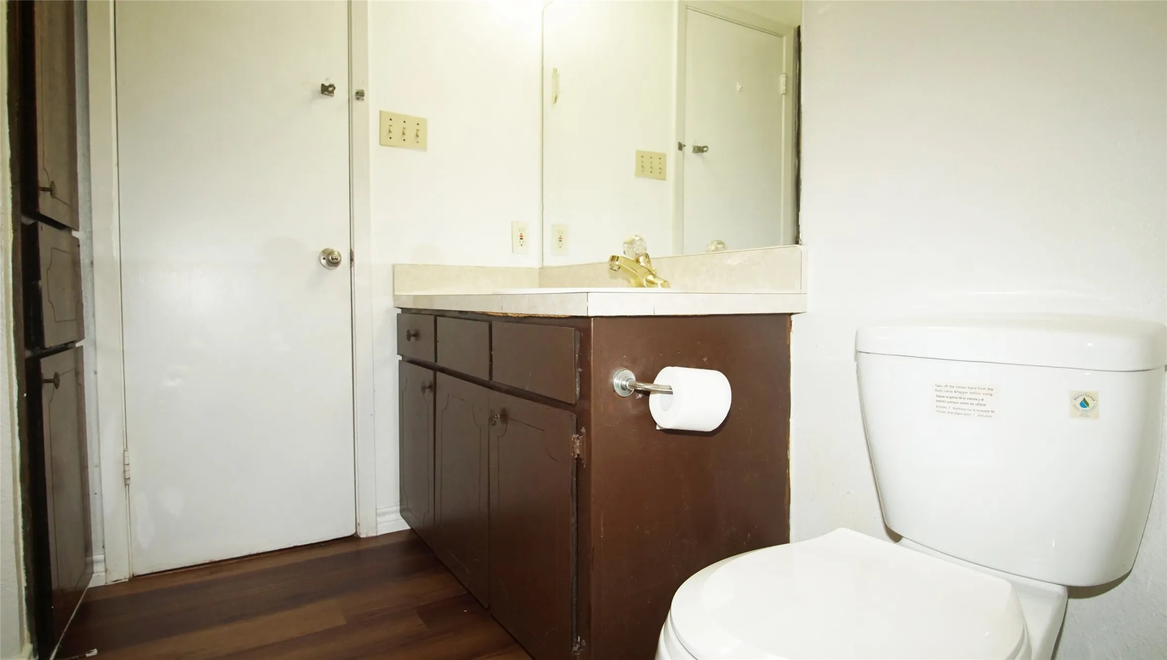 Half bathroom with vanity and wood finished floors