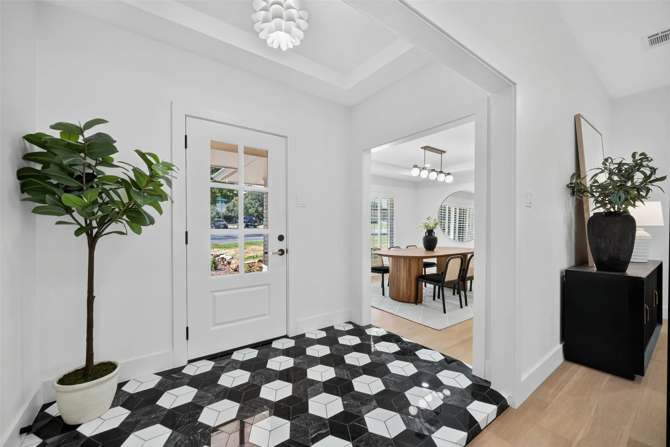 Entryway featuring geometric tile flooring, a paneled door with divided lites, and a coffered ceiling