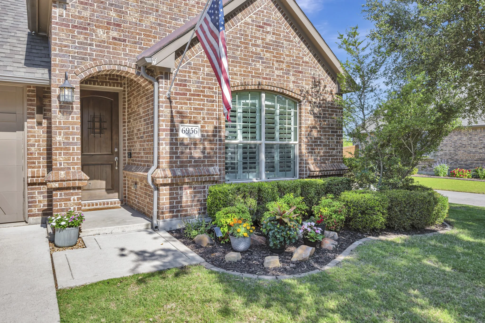 Brick exterior featuring an arched entryway and covered porch
