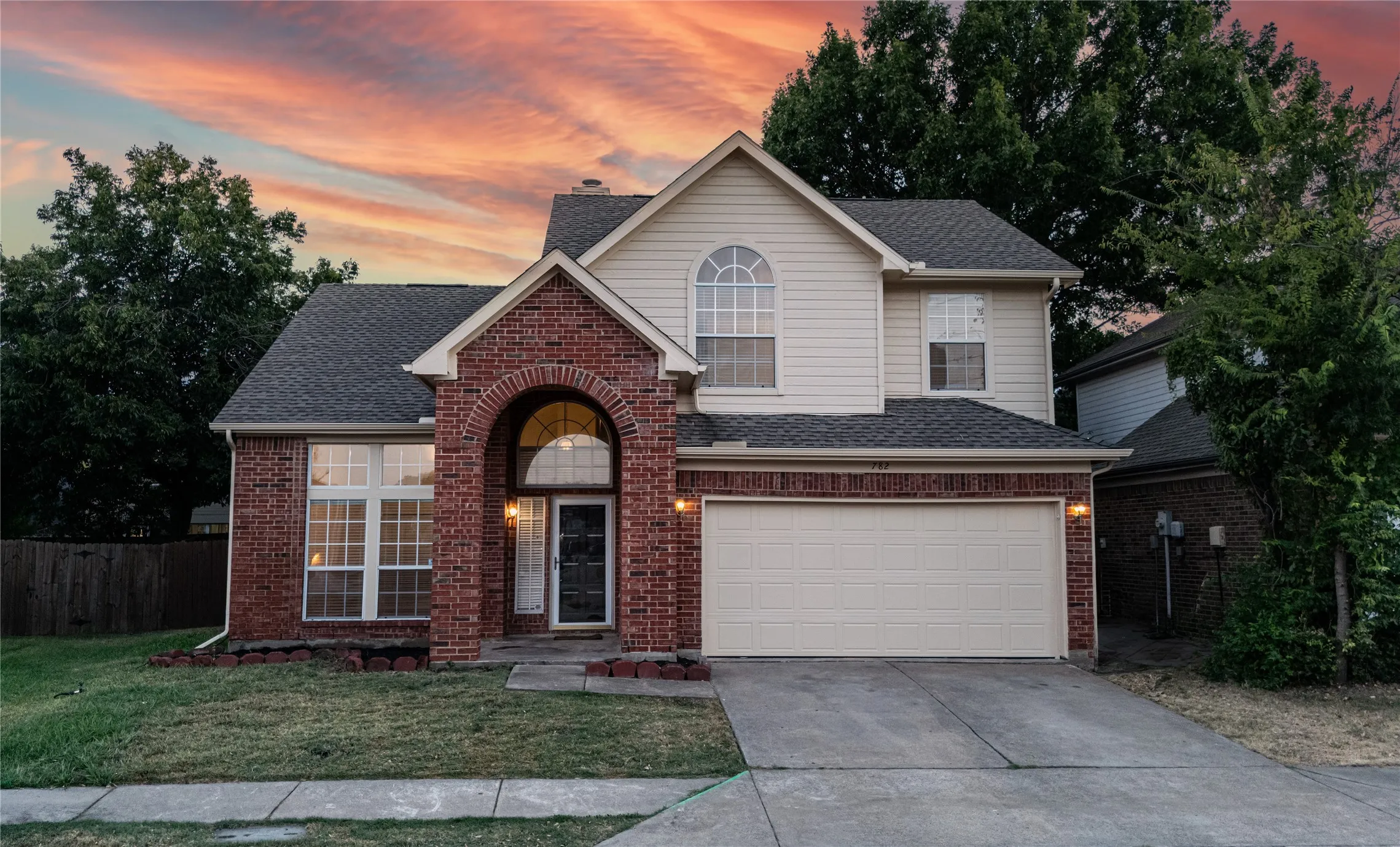 Brick and siding exterior with an arched entry