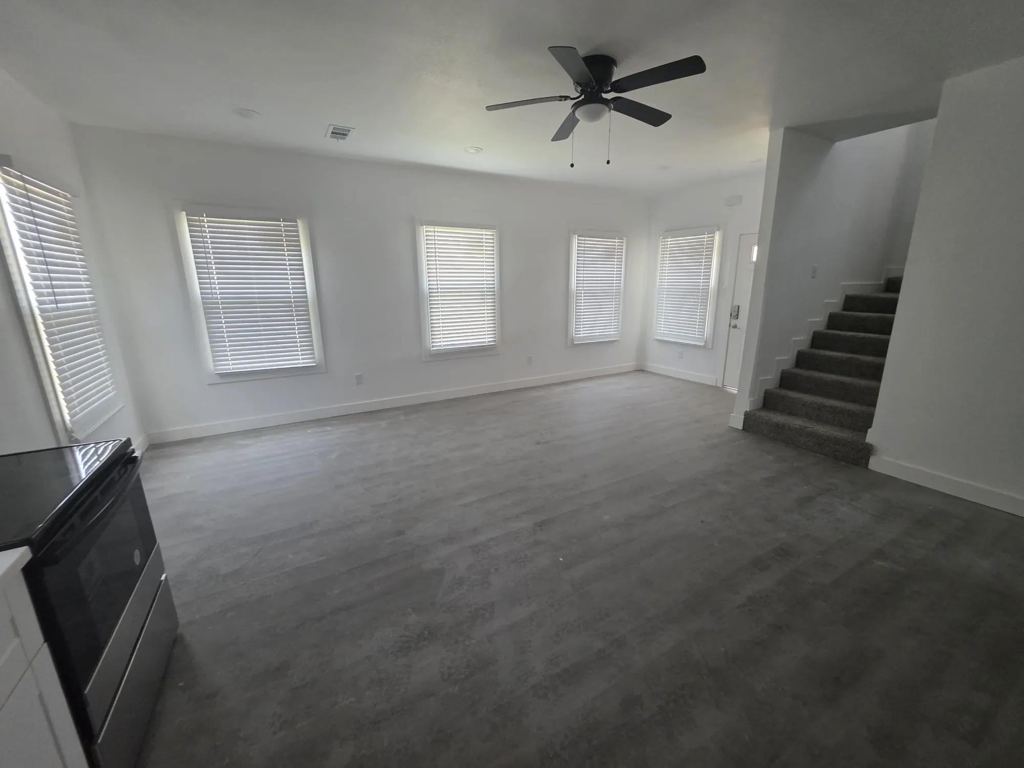 Open-concept living space with multiple windows, recessed lighting, and a ceiling fan