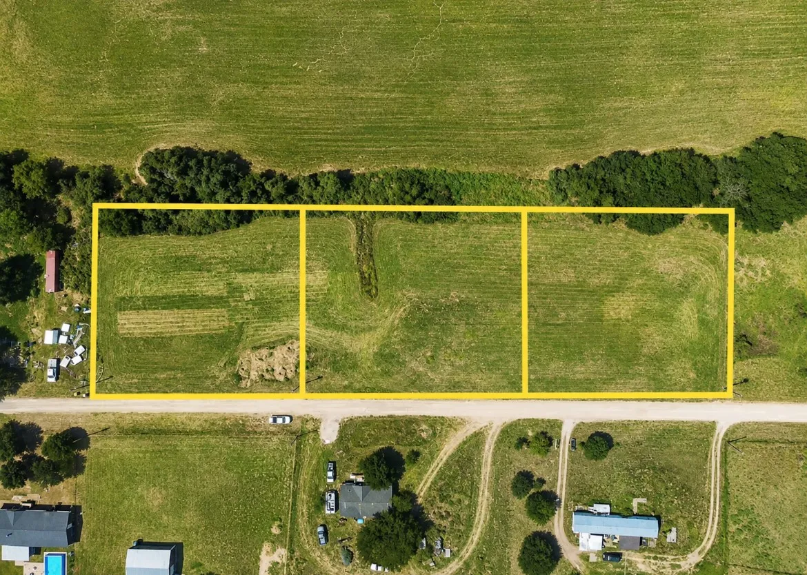 Expansive agricultural land featuring a verdant field and established tree line