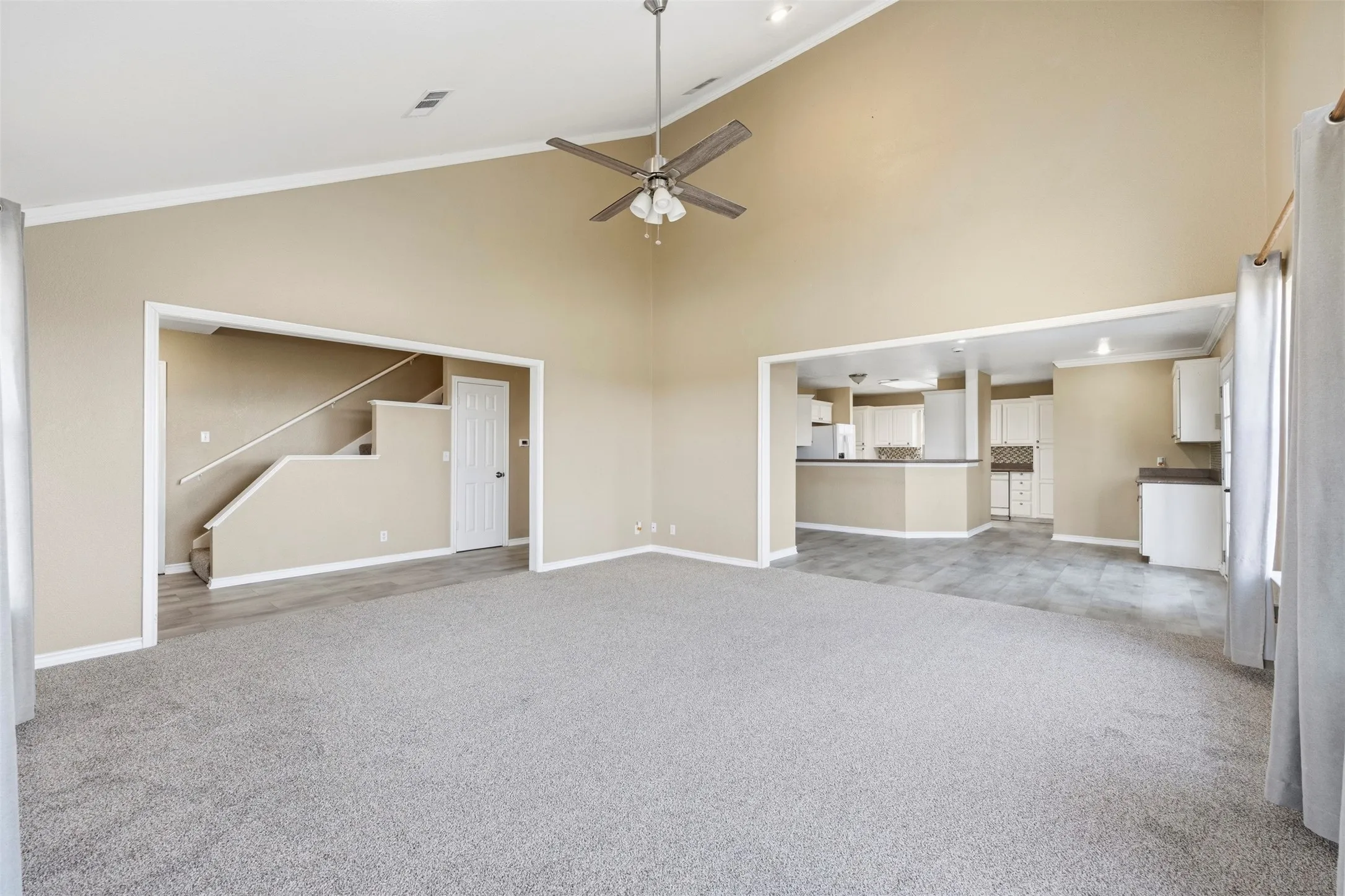 Vaulted ceiling with recessed lighting and ceiling fan, neutral paint finishes, and wood-finish flooring