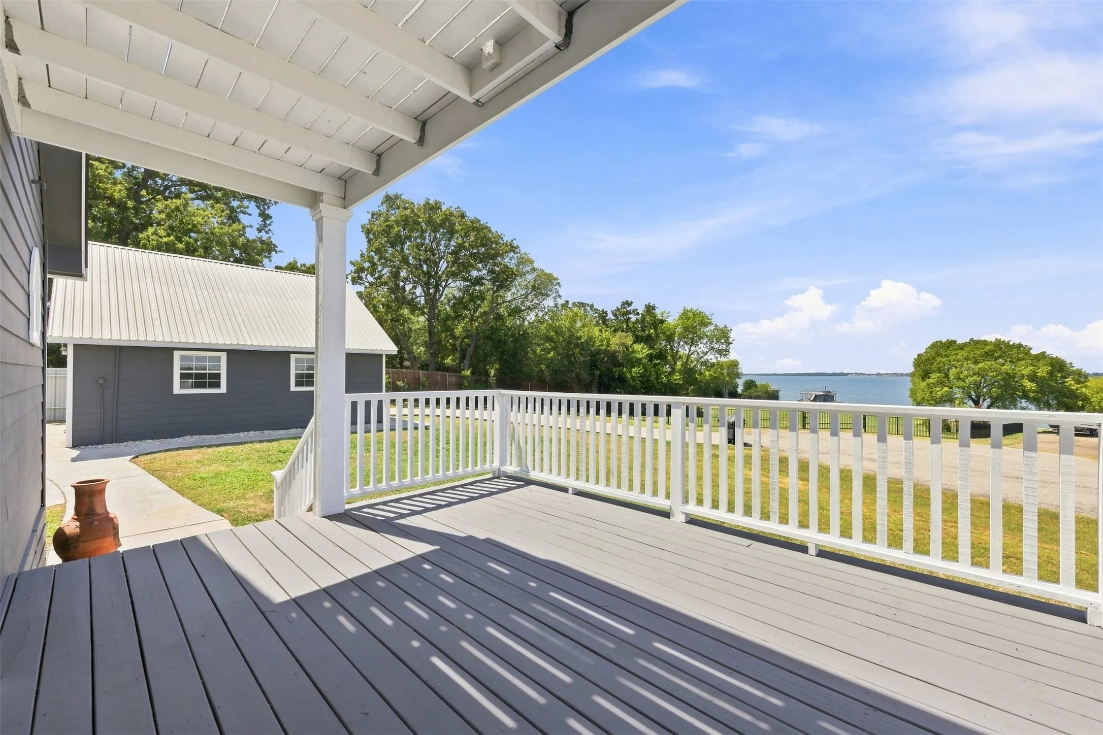 Covered porch with wood-finish decking and white railings