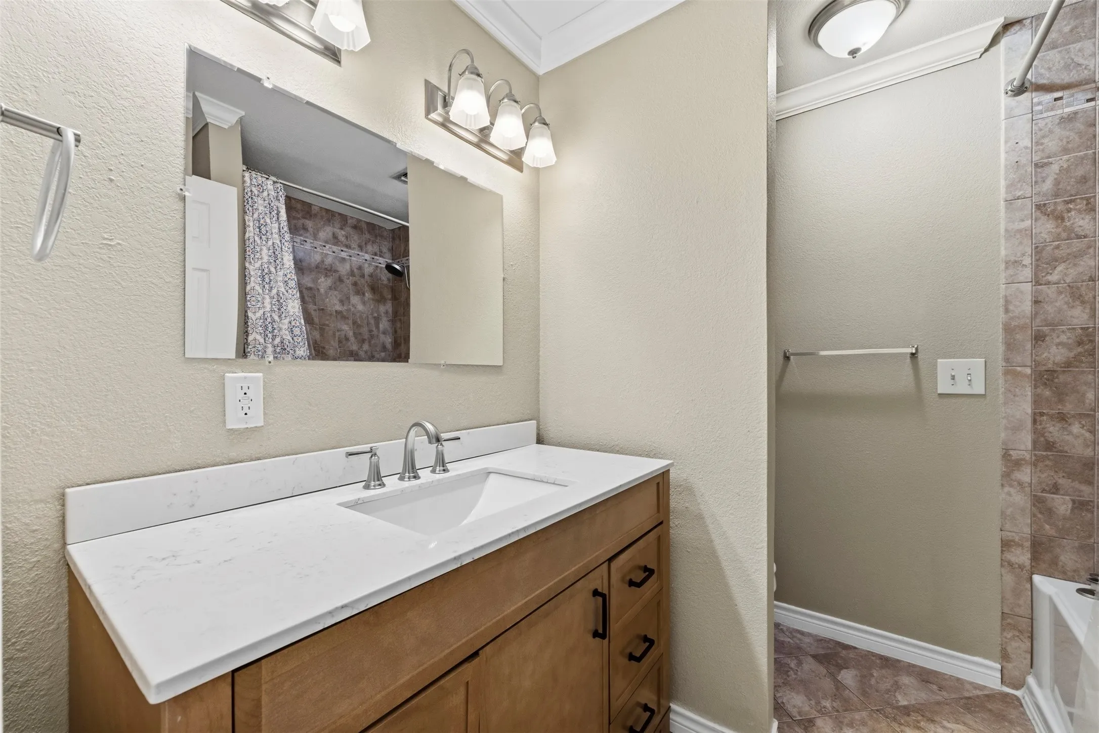 Light wood-finish vanity with a white countertop and undermount sink