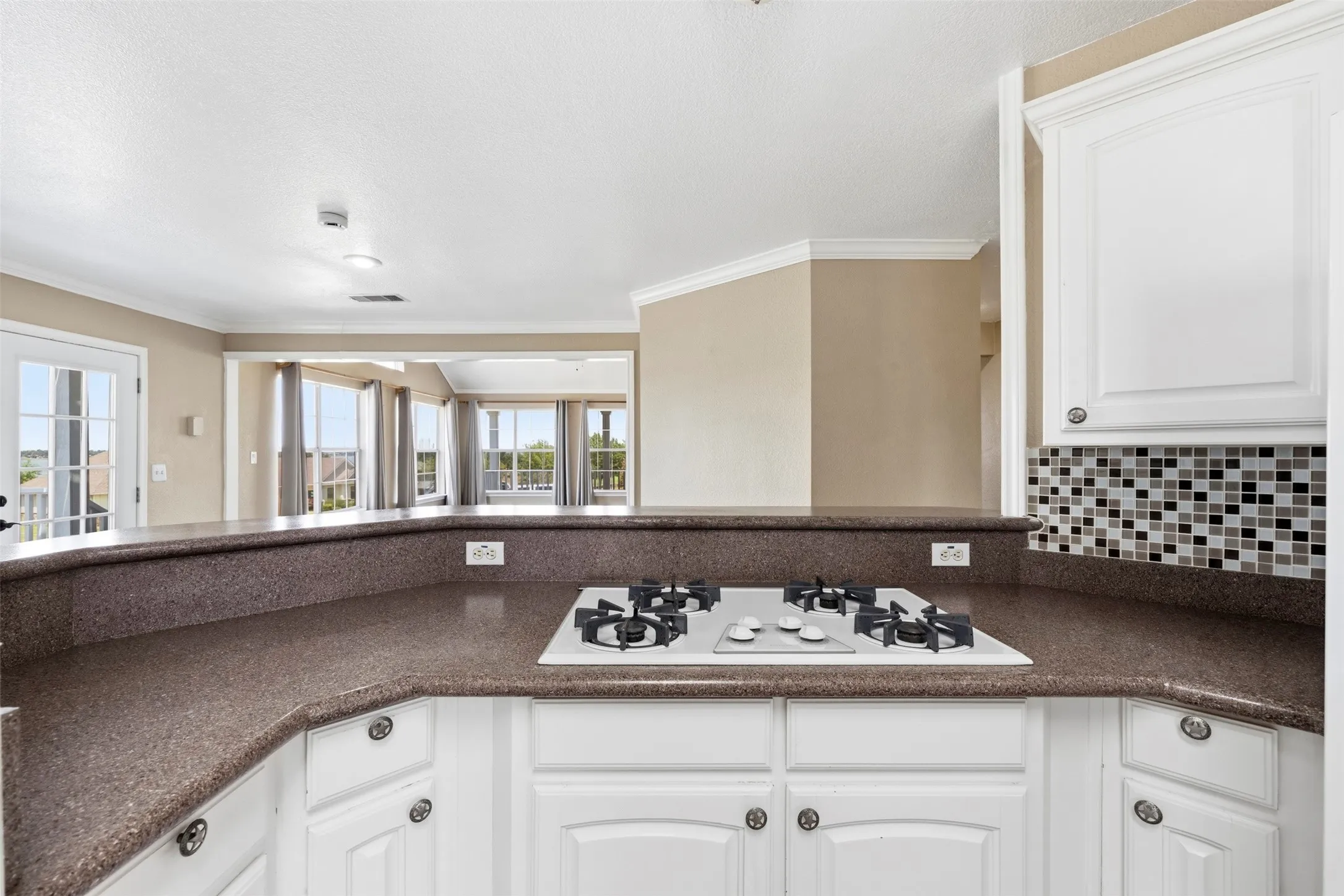 Kitchen featuring white cabinetry, a built-in gas cooktop, and a mosaic tile backsplash