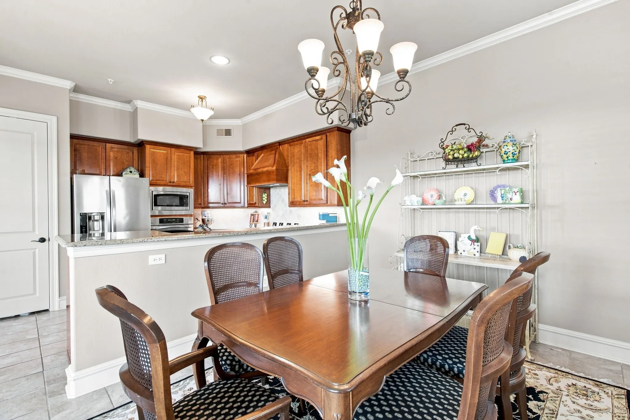 Kitchen features wood cabinetry, stainless steel appliances, and granite counters.