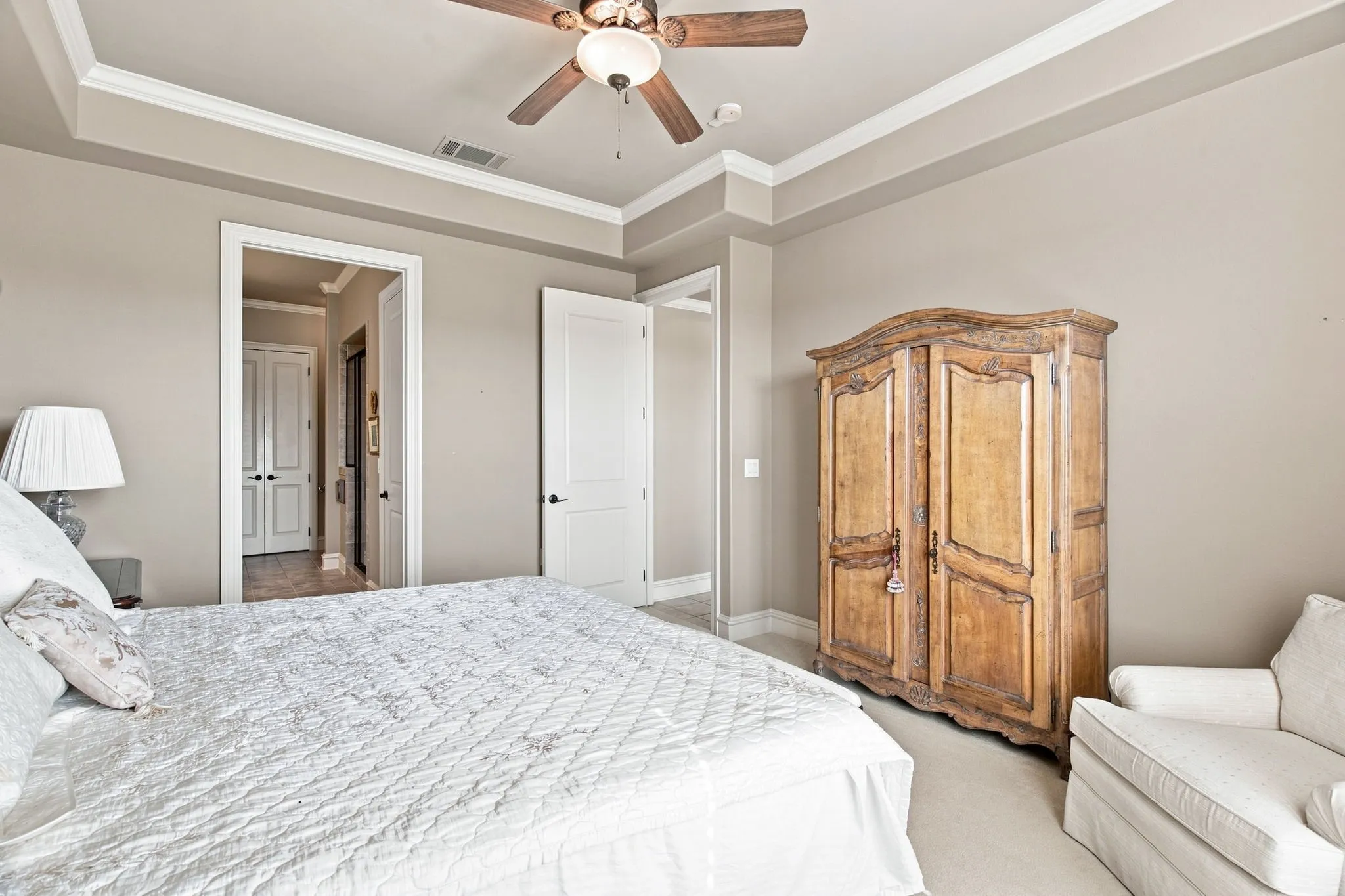 Tray ceiling with crown molding and a ceiling fan