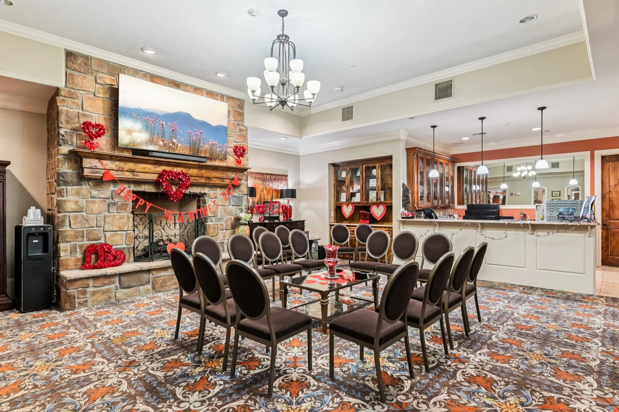 Stone-clad fireplace with a wood mantle, built-in reception desk, and decorative area rug