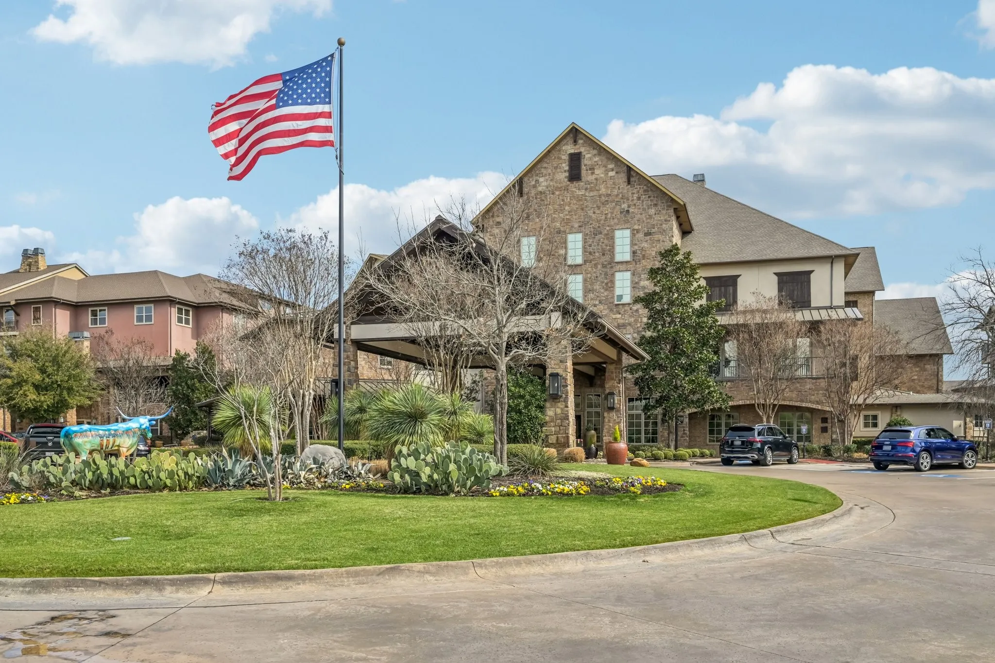 Stone exterior with multiple gables, covered entrance, and mature landscaping