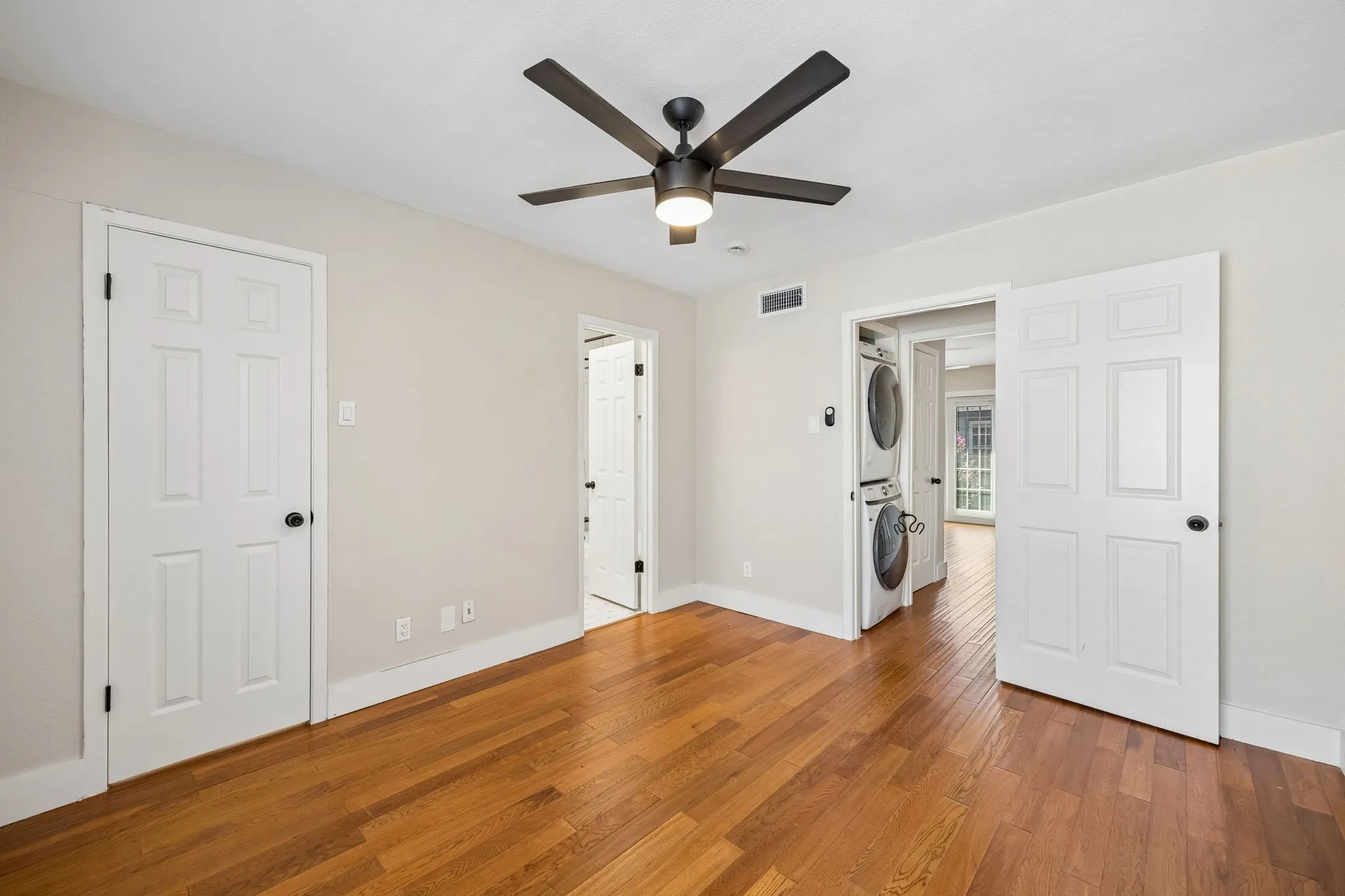 Hardwood flooring with white baseboards and neutral wall paint