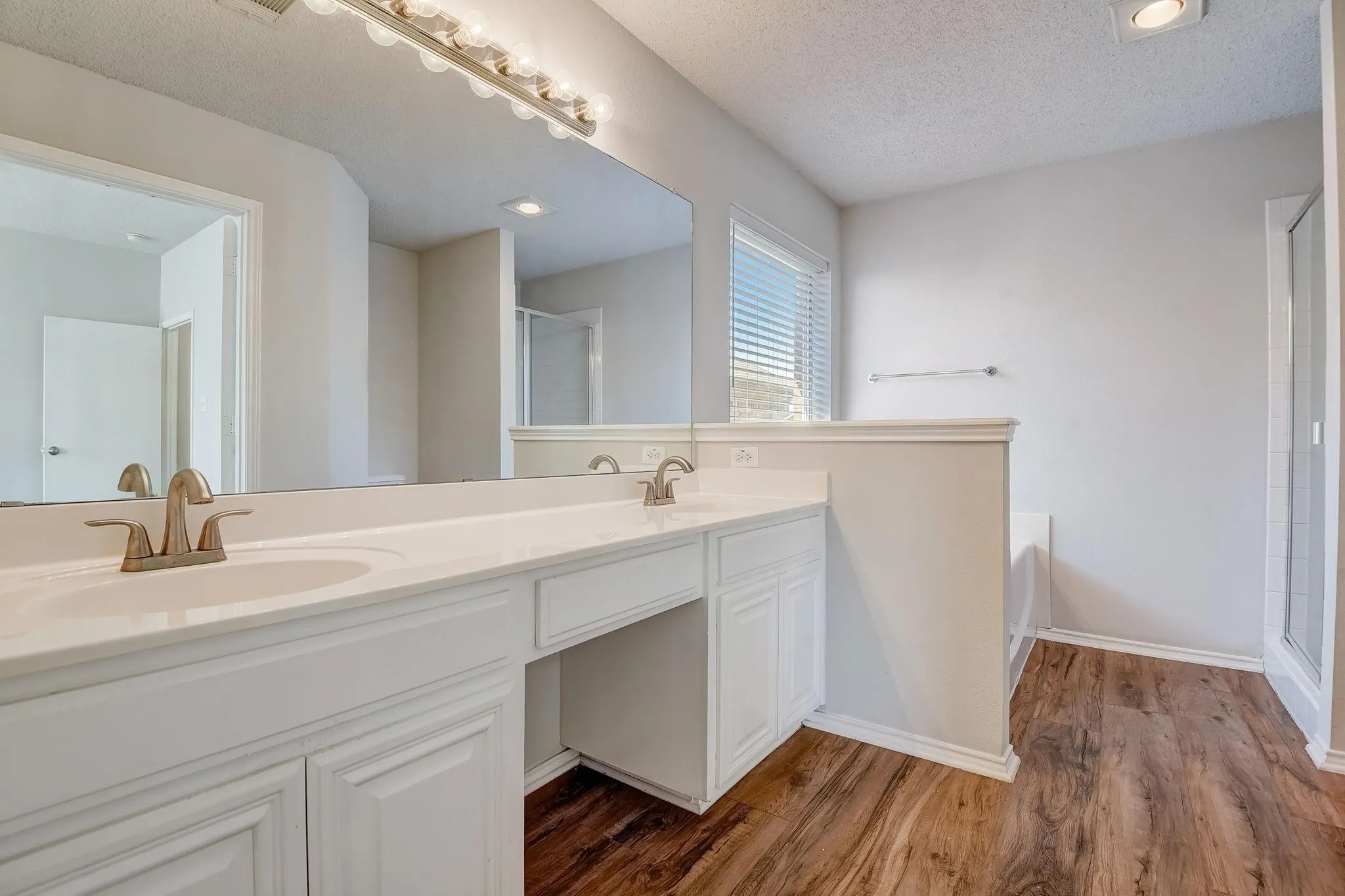 Bathroom featuring a garden tub, wood finished floors, a sink, and a shower stall