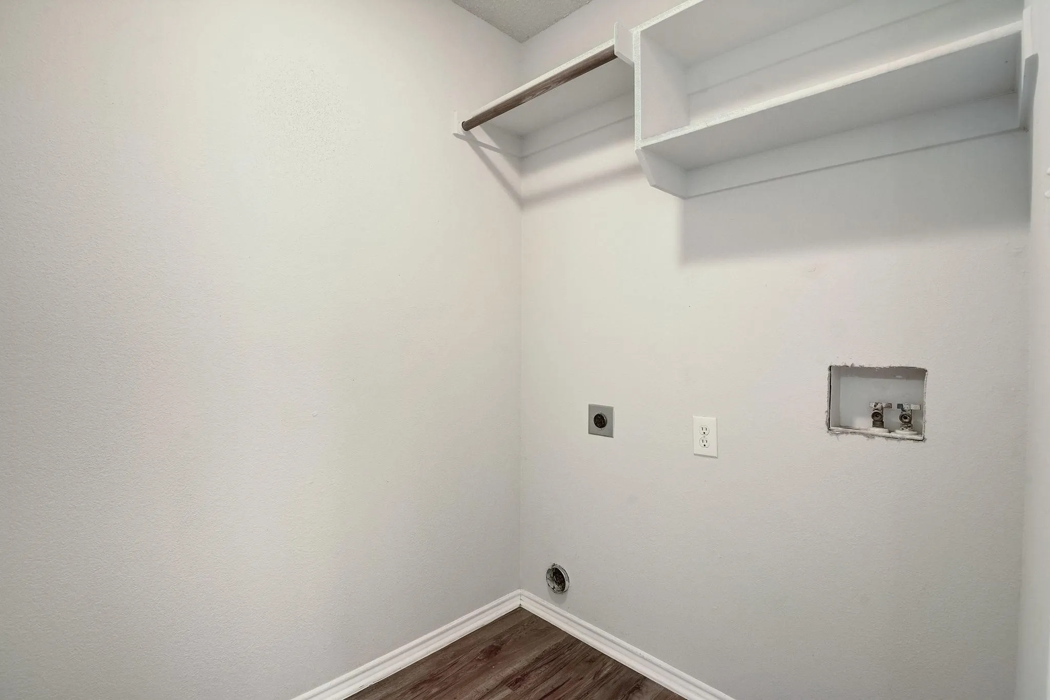 Laundry area featuring hookup for a washing machine, laundry area, wood finished floors, baseboards, and electric dryer hookup