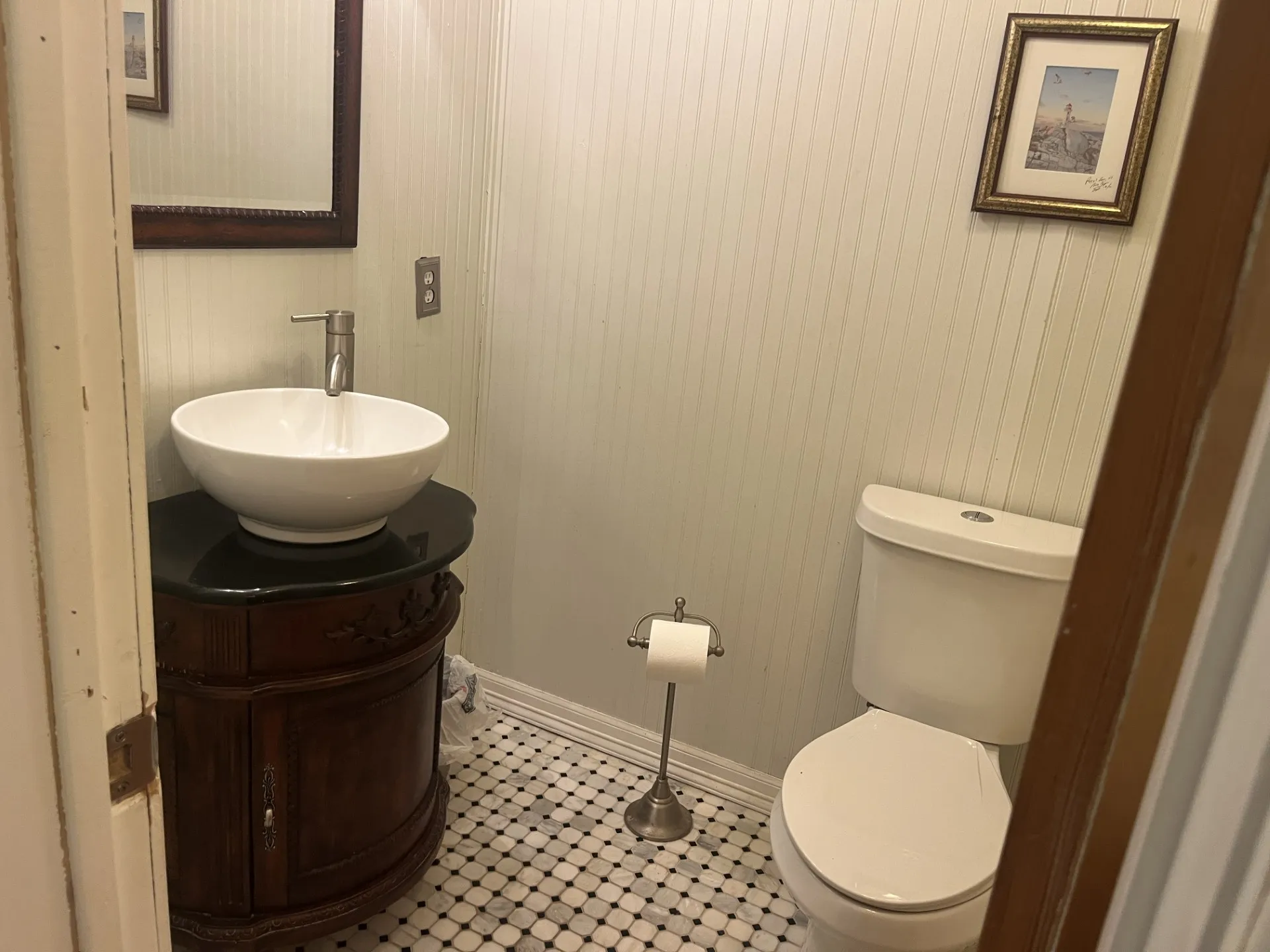 Pedestal sink with a dark countertop, white vessel sink, and brushed nickel faucet