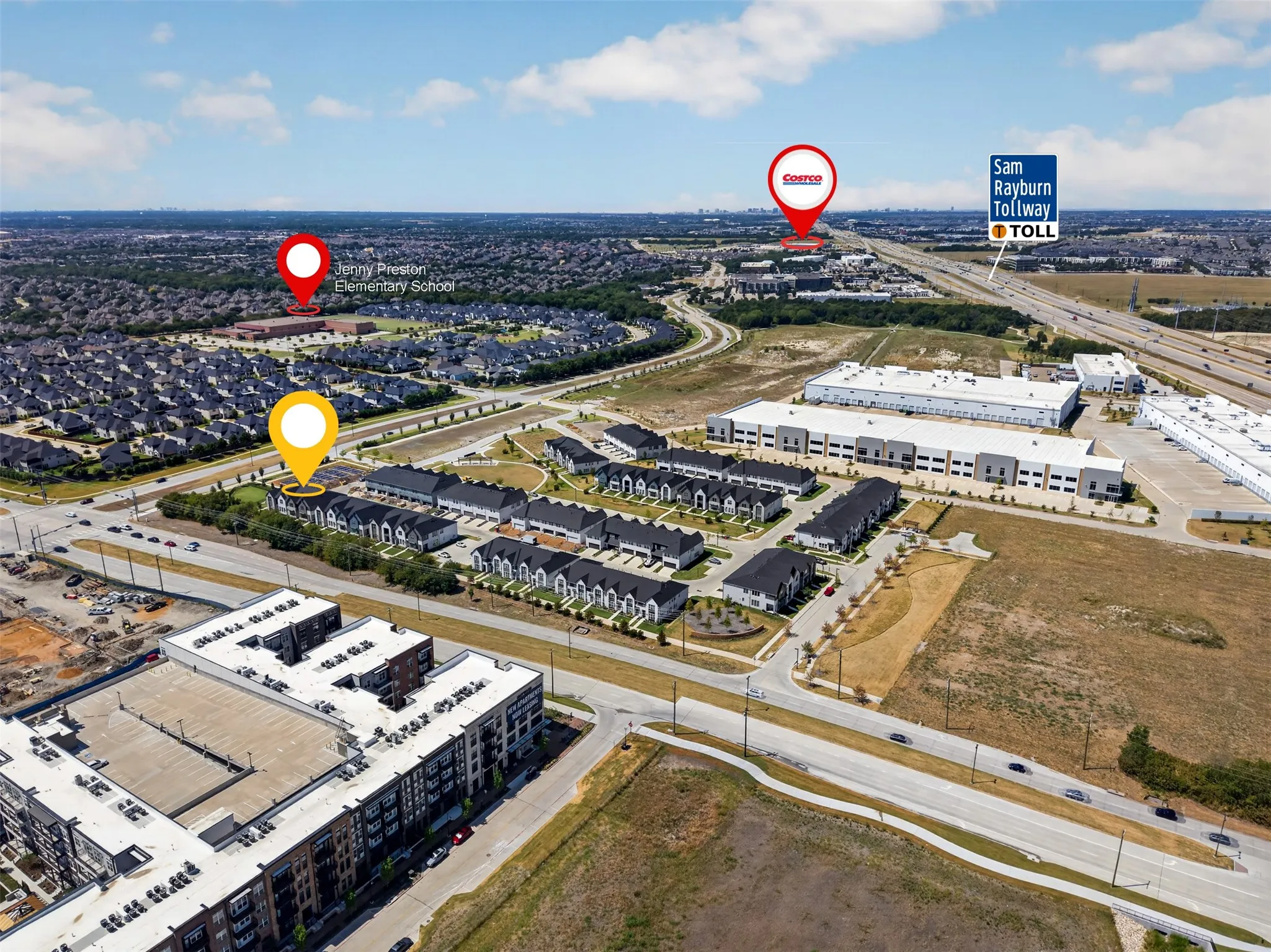 Aerial perspective showcasing a residential development, commercial buildings, and major roadways