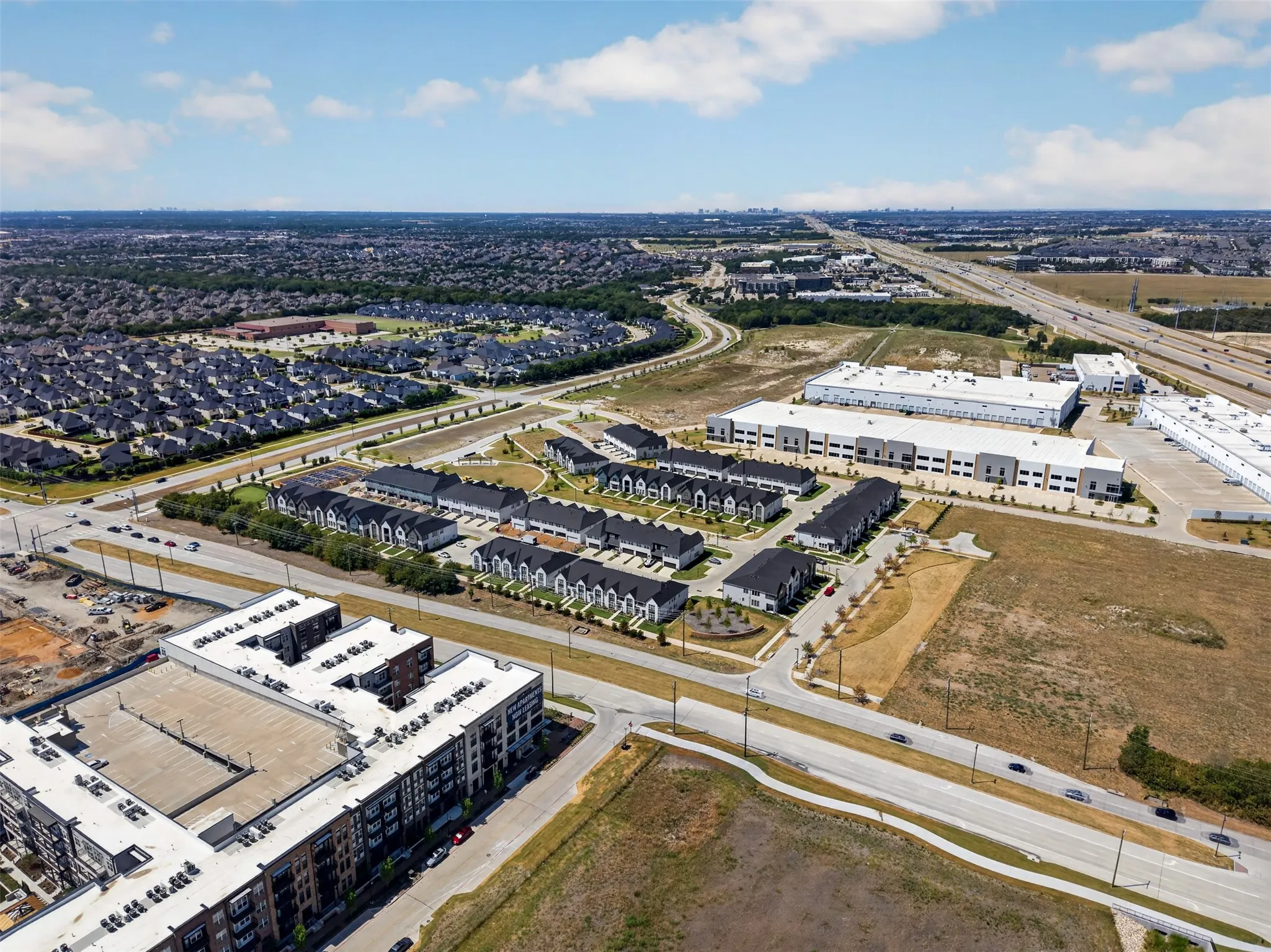 Modern residential development featuring townhomes, apartment buildings, and commercial structures