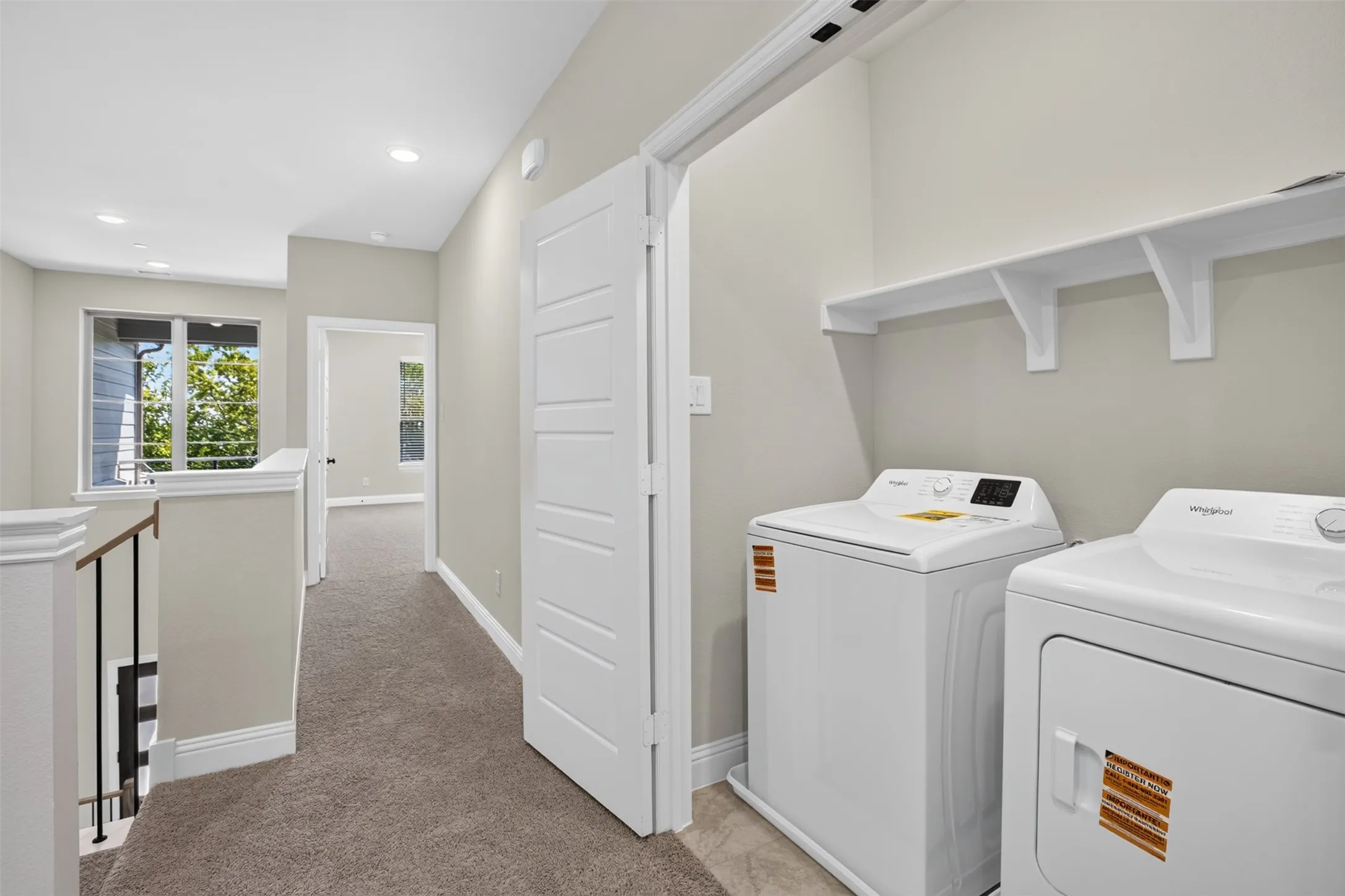 Laundry area featuring a full-size washer and dryer, tile flooring, and integrated shelving