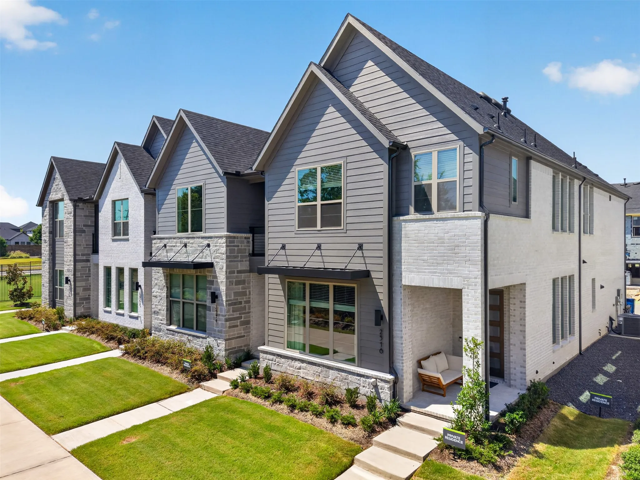 Contemporary exterior with a covered entry, gabled rooflines, stone accents, and horizontal siding