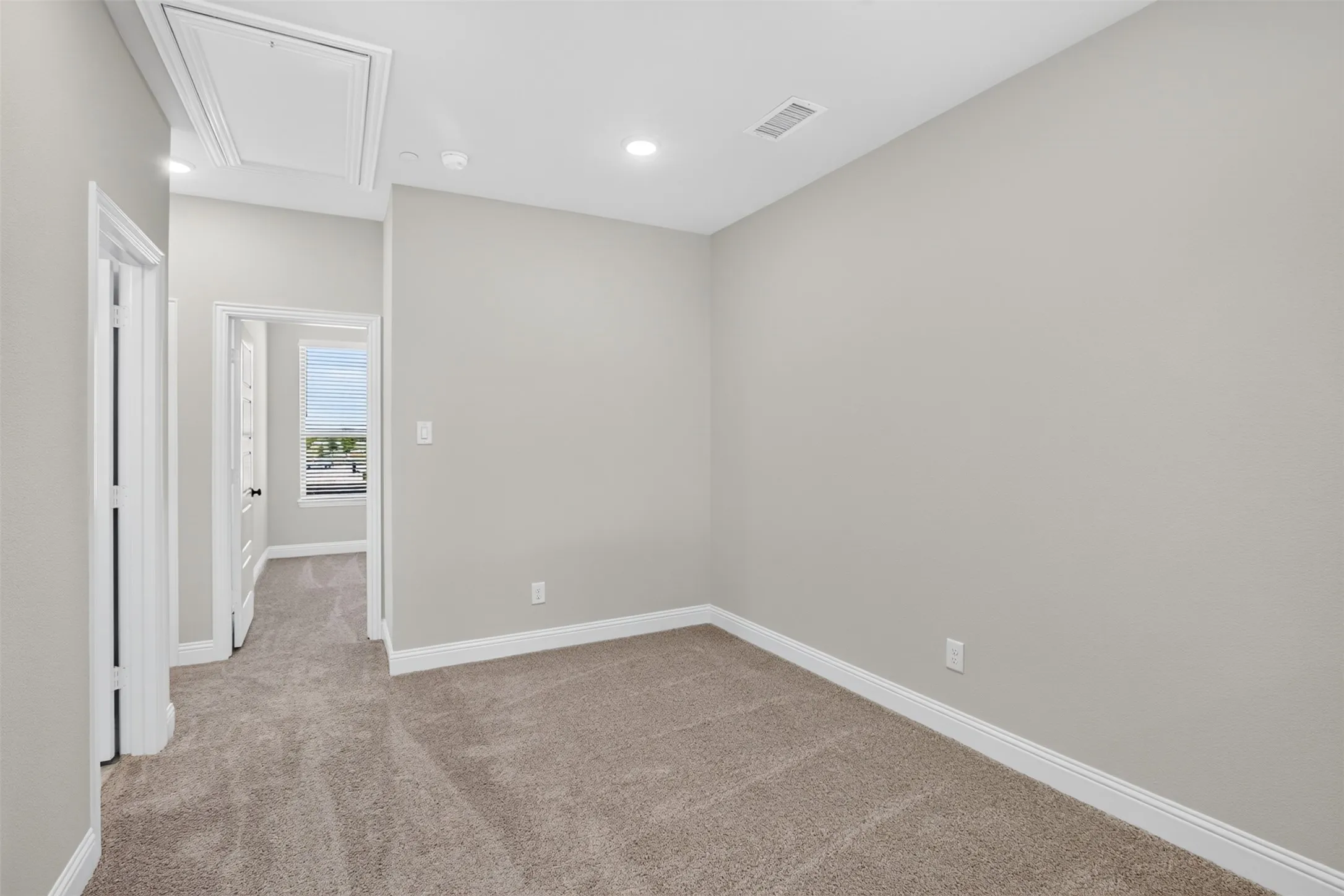 Plush carpet flooring in a neutral tone, light gray wall paint, white trim, recessed lighting, and a window with horizontal blinds