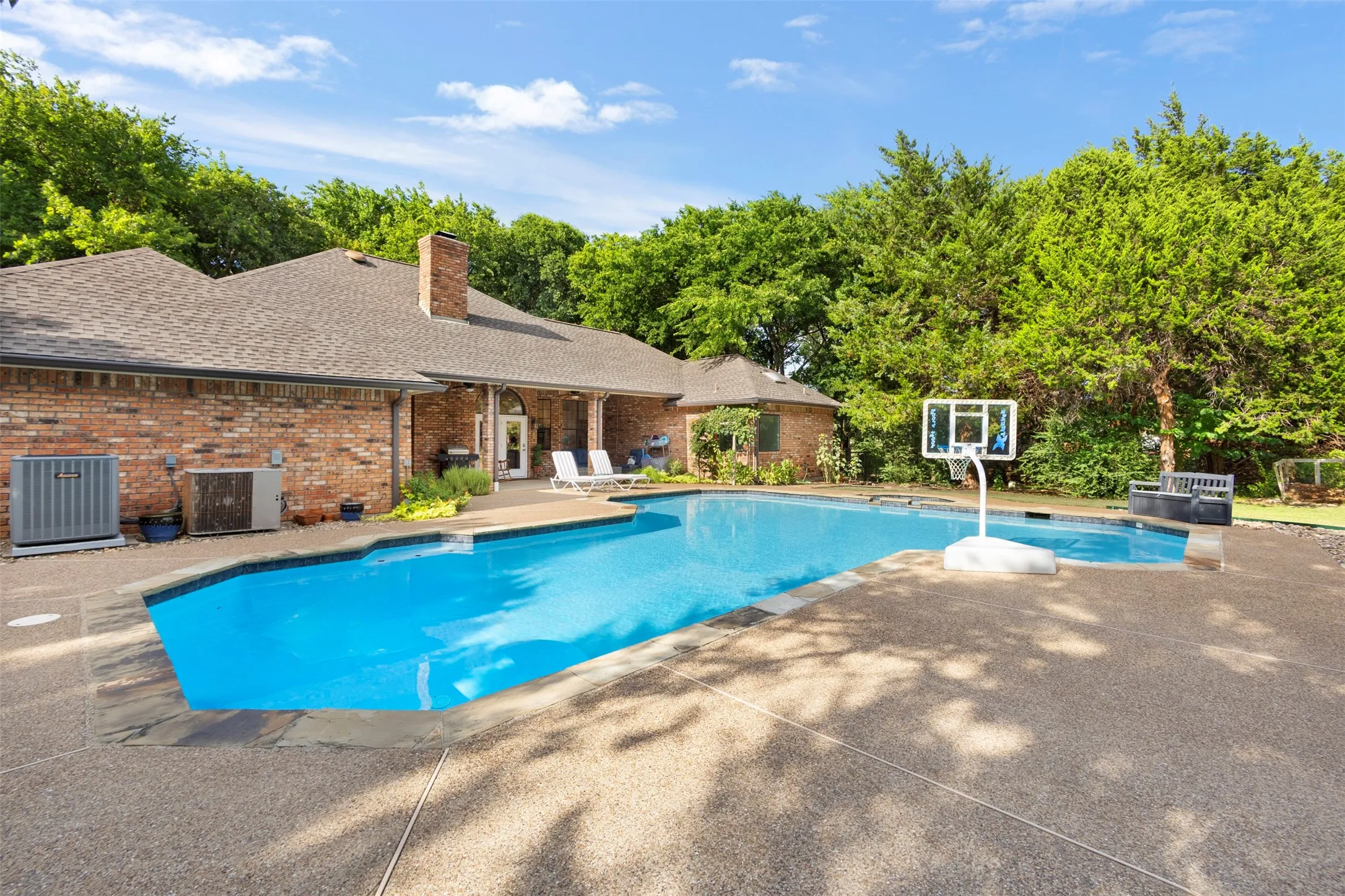 Brick exterior with a gabled roofline, complemented by an in-ground swimming pool