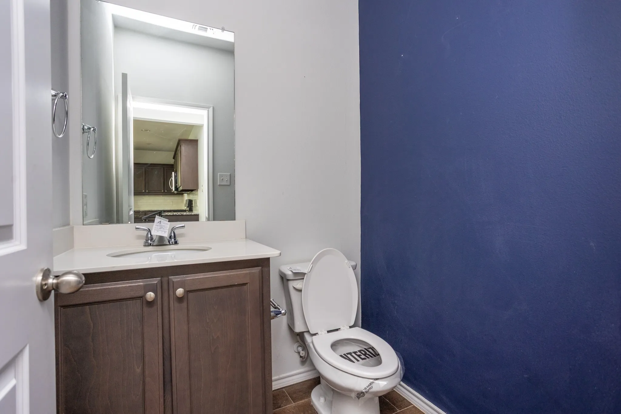 Vanity with wood-finish cabinetry, integrated sink, and chrome faucet