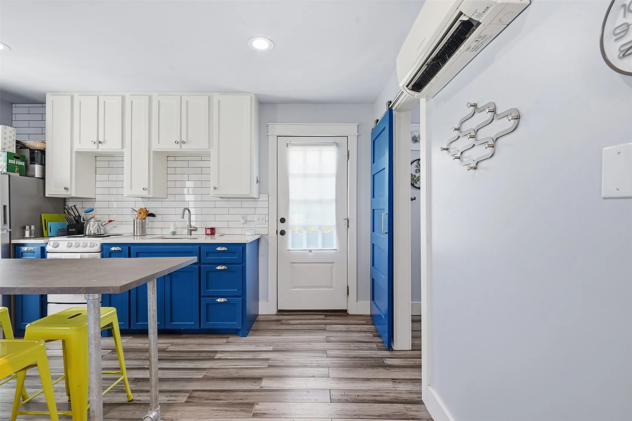 Kitchen featuring two-tone cabinetry, subway tile backsplash, wood-finish flooring, and recessed lighting