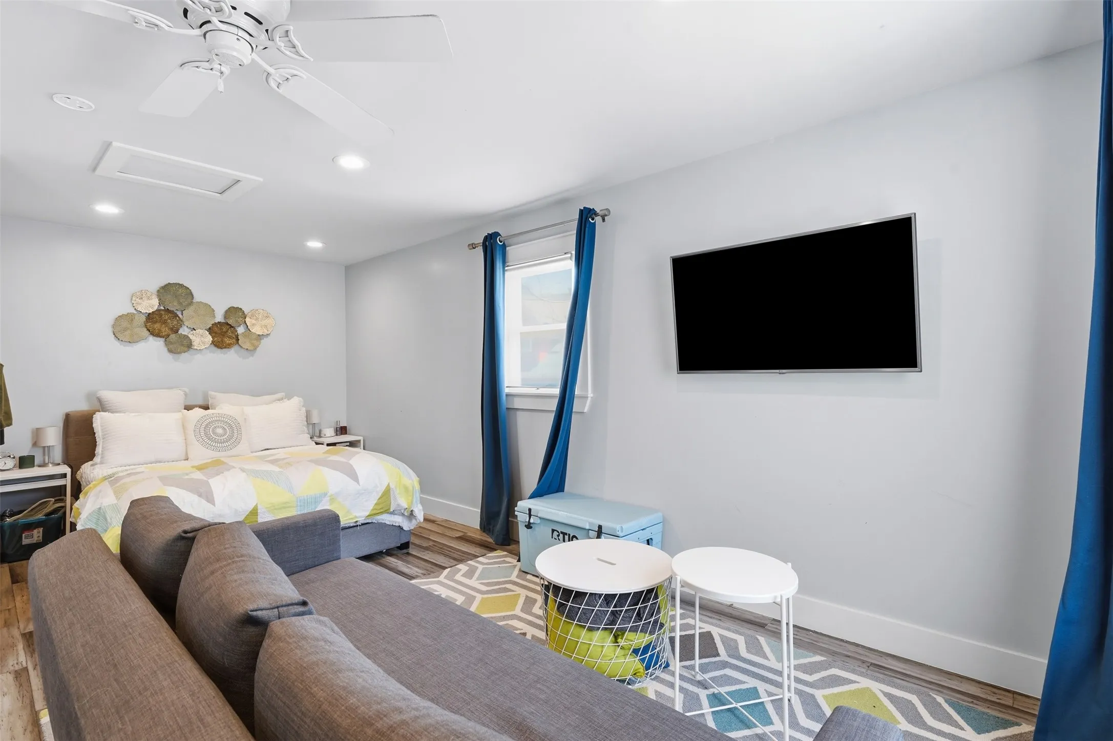 Recessed lighting, ceiling fan, wood-finish flooring, and a wall-mounted display