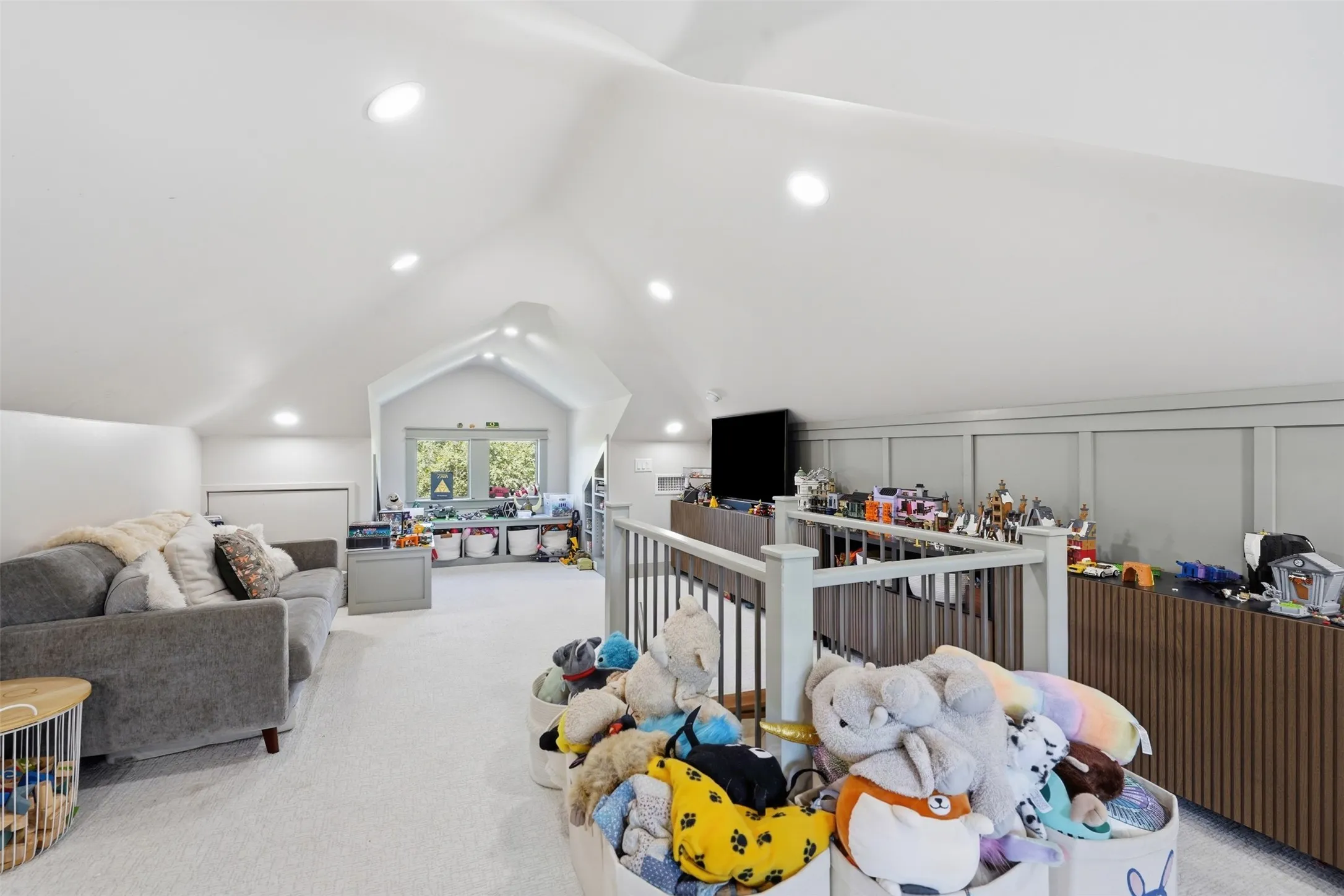 Expansive bonus room with vaulted ceilings, recessed lighting, carpet flooring, a window dormer, and a built-in media console