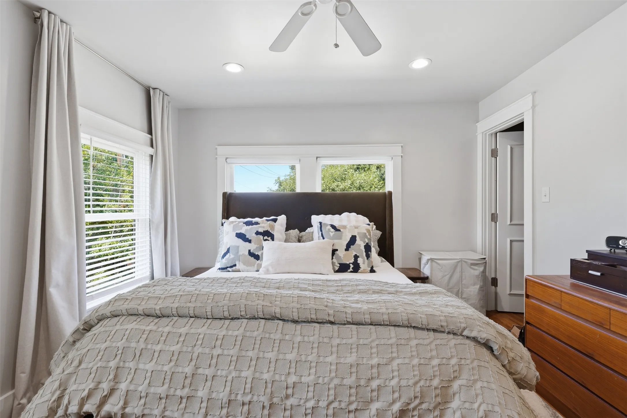 Recessed lighting, ceiling fan, multiple windows with blinds, and paneled interior door