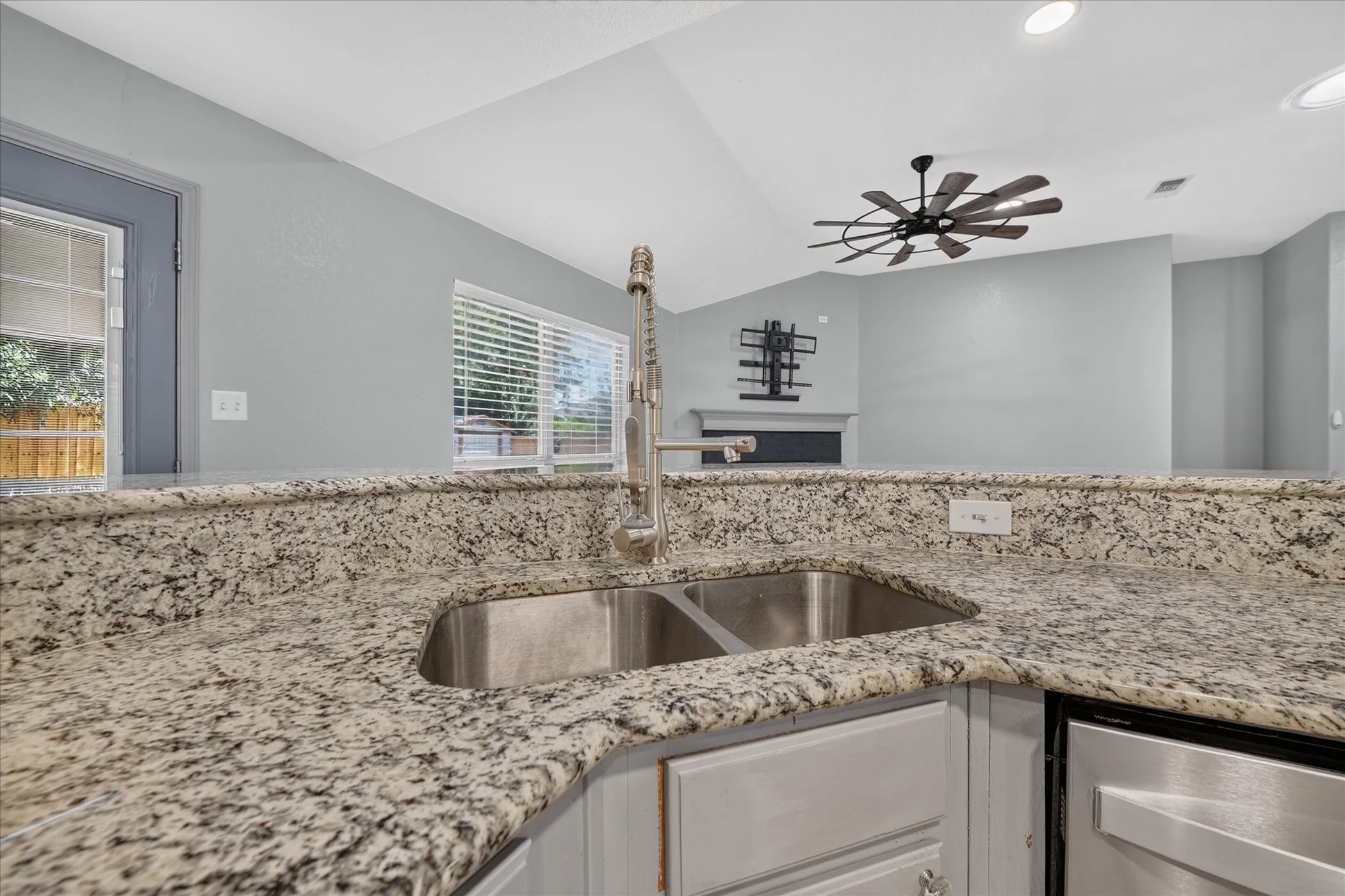 Granite-finish countertops with an undermount double basin stainless steel sink and a pull-down faucet