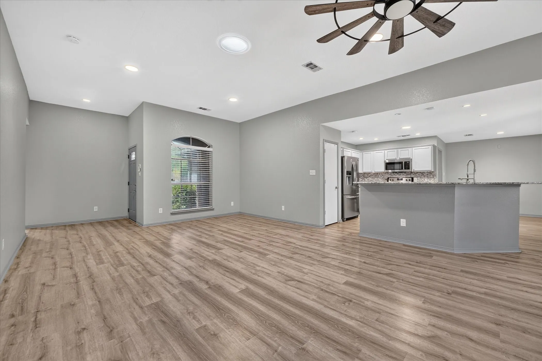 Wood-finish flooring throughout, recessed lighting, and a modern ceiling fan
