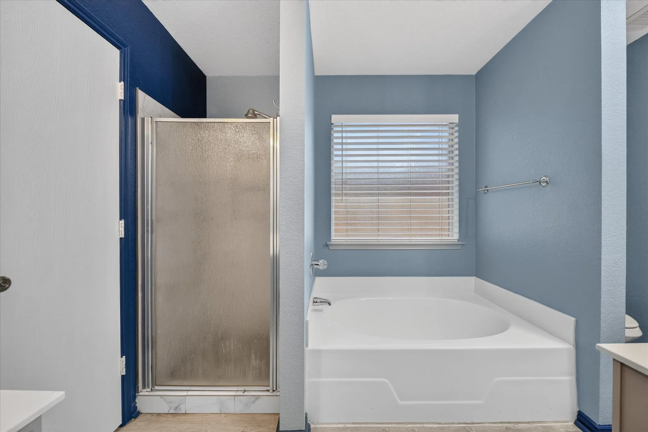 Built-in soaking tub with a window and horizontal blinds